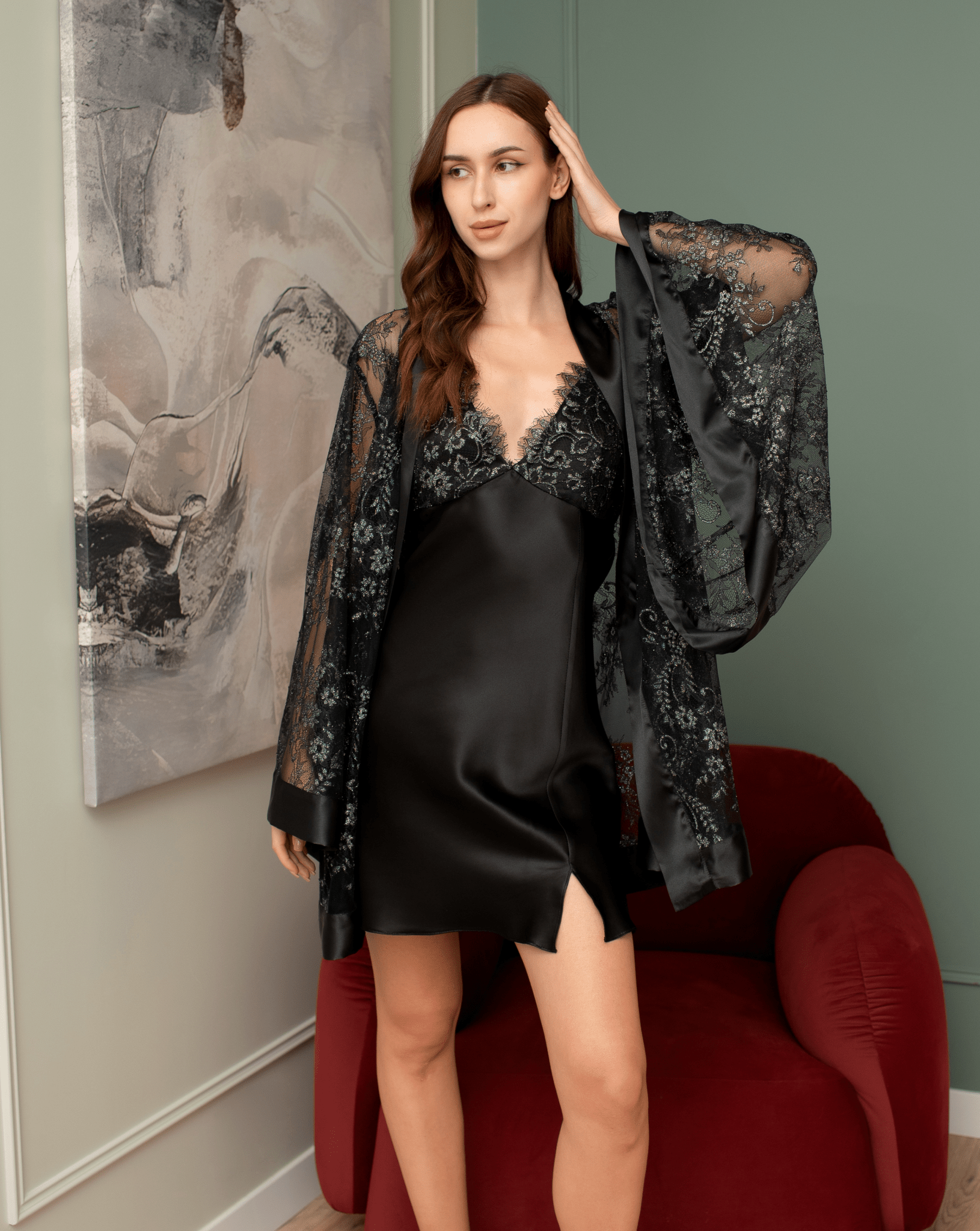 Black lace robe worn over a short black nightdress in moody lighting.