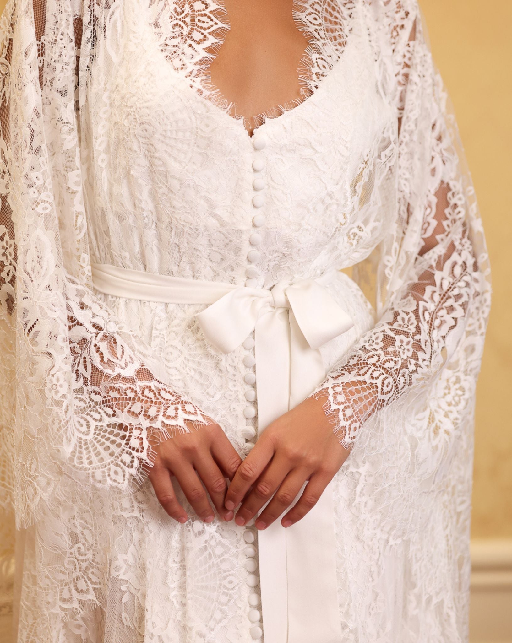 Bridal-inspired lace robe and nightgown set by Kafemme, photographed against a soft-toned wall