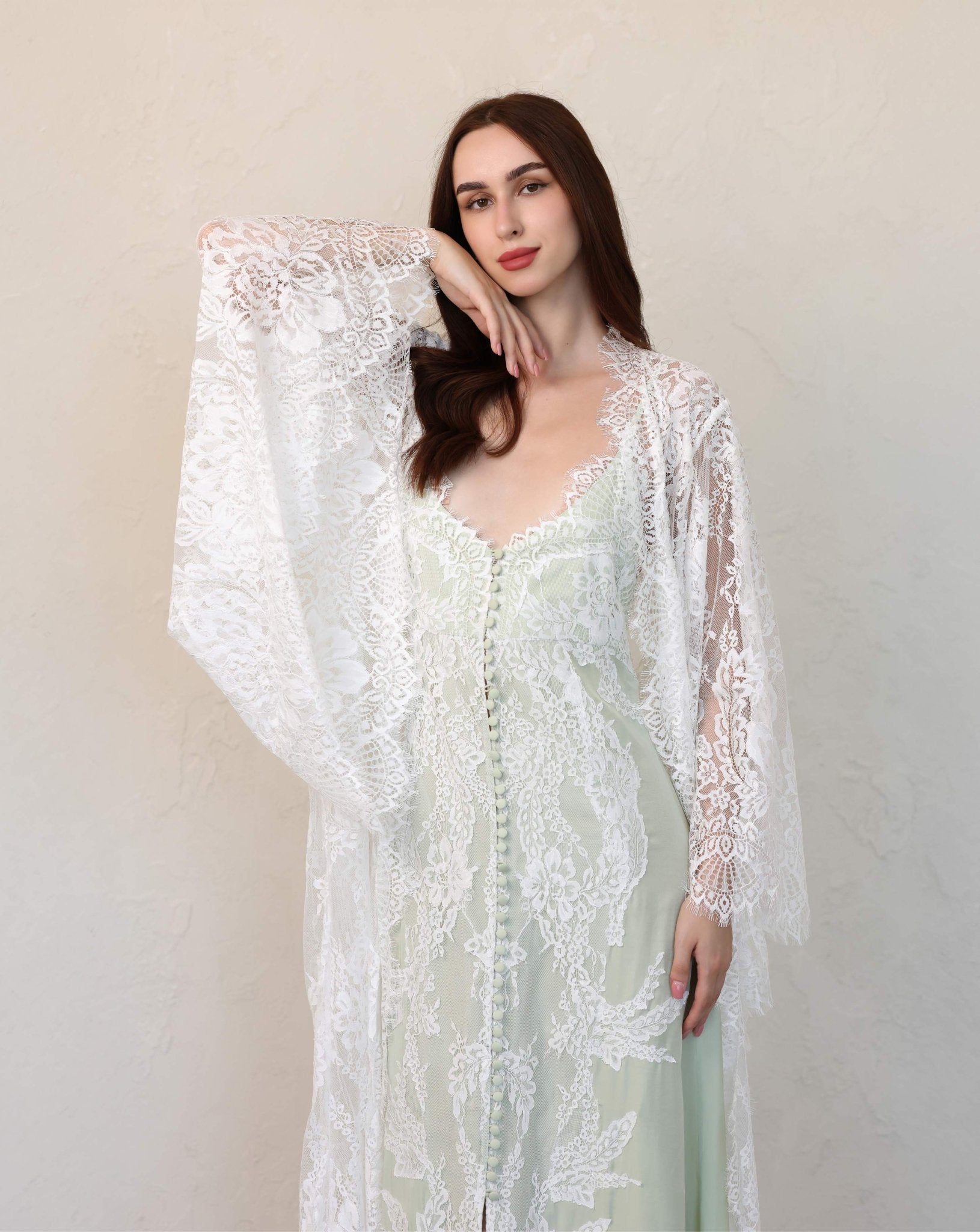 White lace robe set by kafemme with long bell sleeves, styled against a soft wall