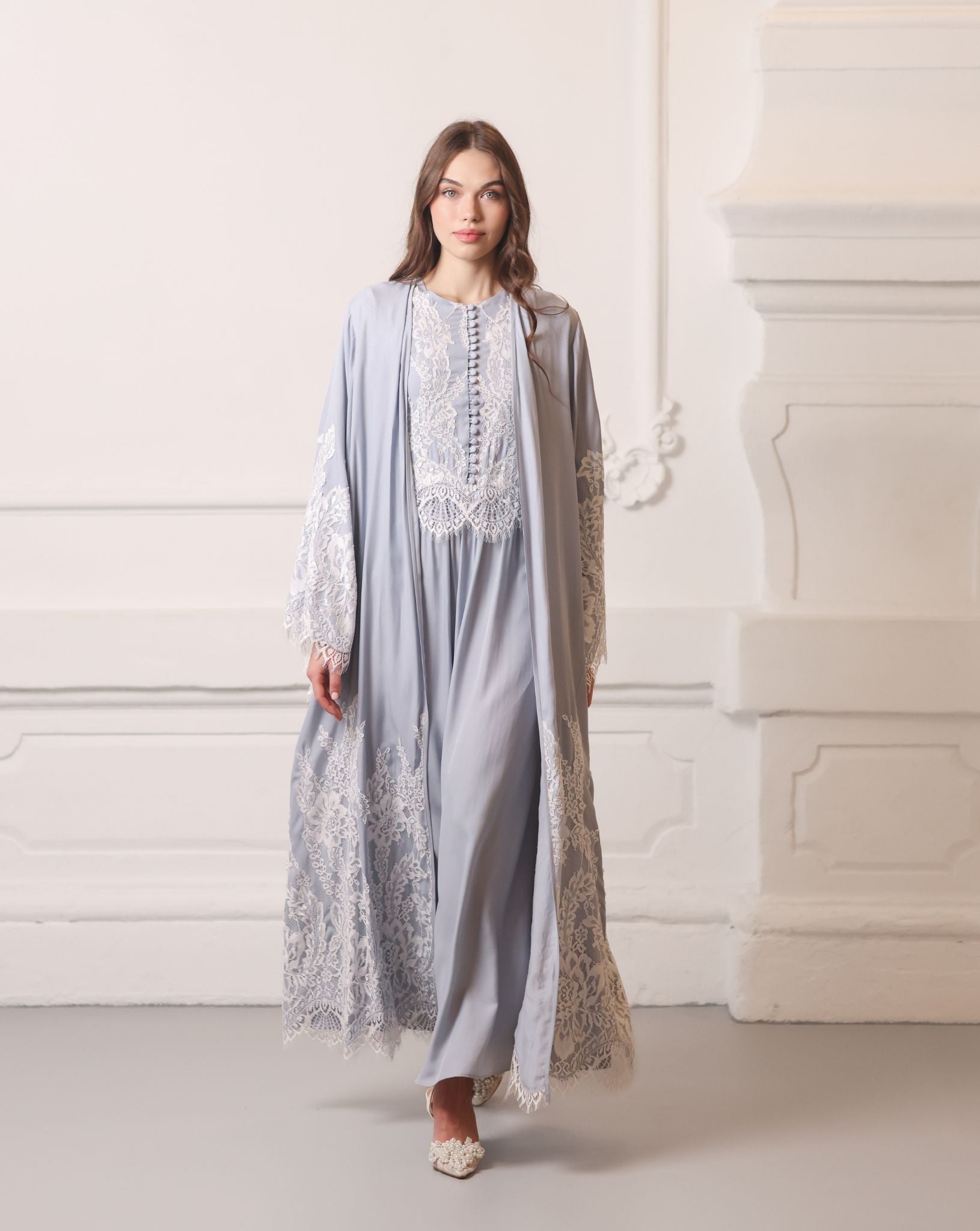 Full-length shot of a woman walking in a lace robe, showing the poetic movement of the viscose fabric.