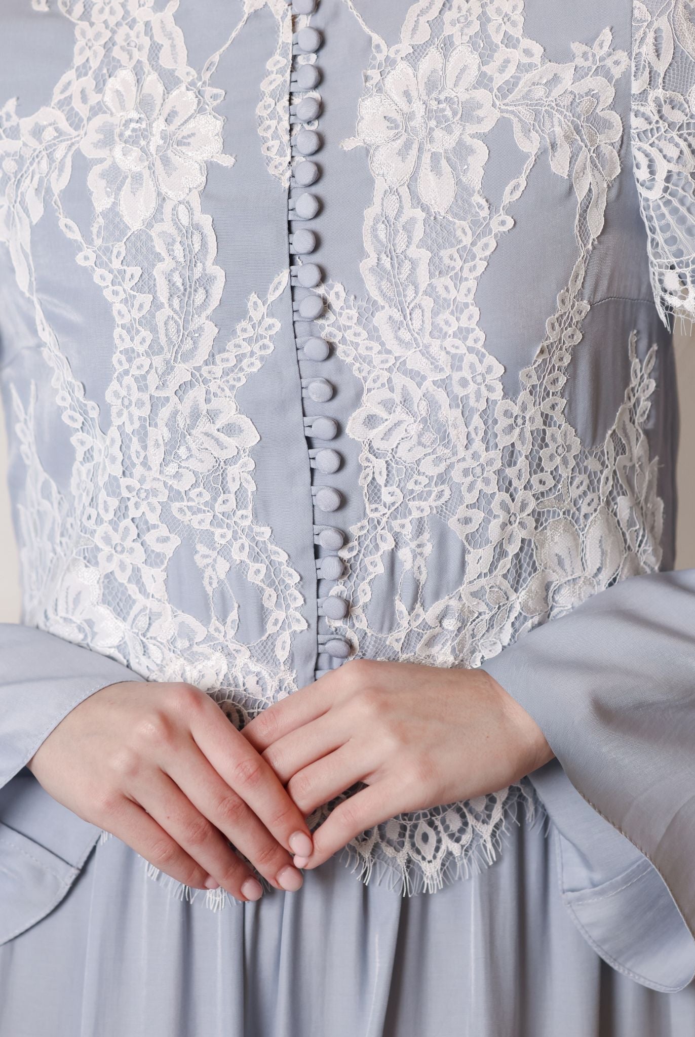 Detailed shot of the high neckline, lace inserts, and small buttons on a modest viscose garment.