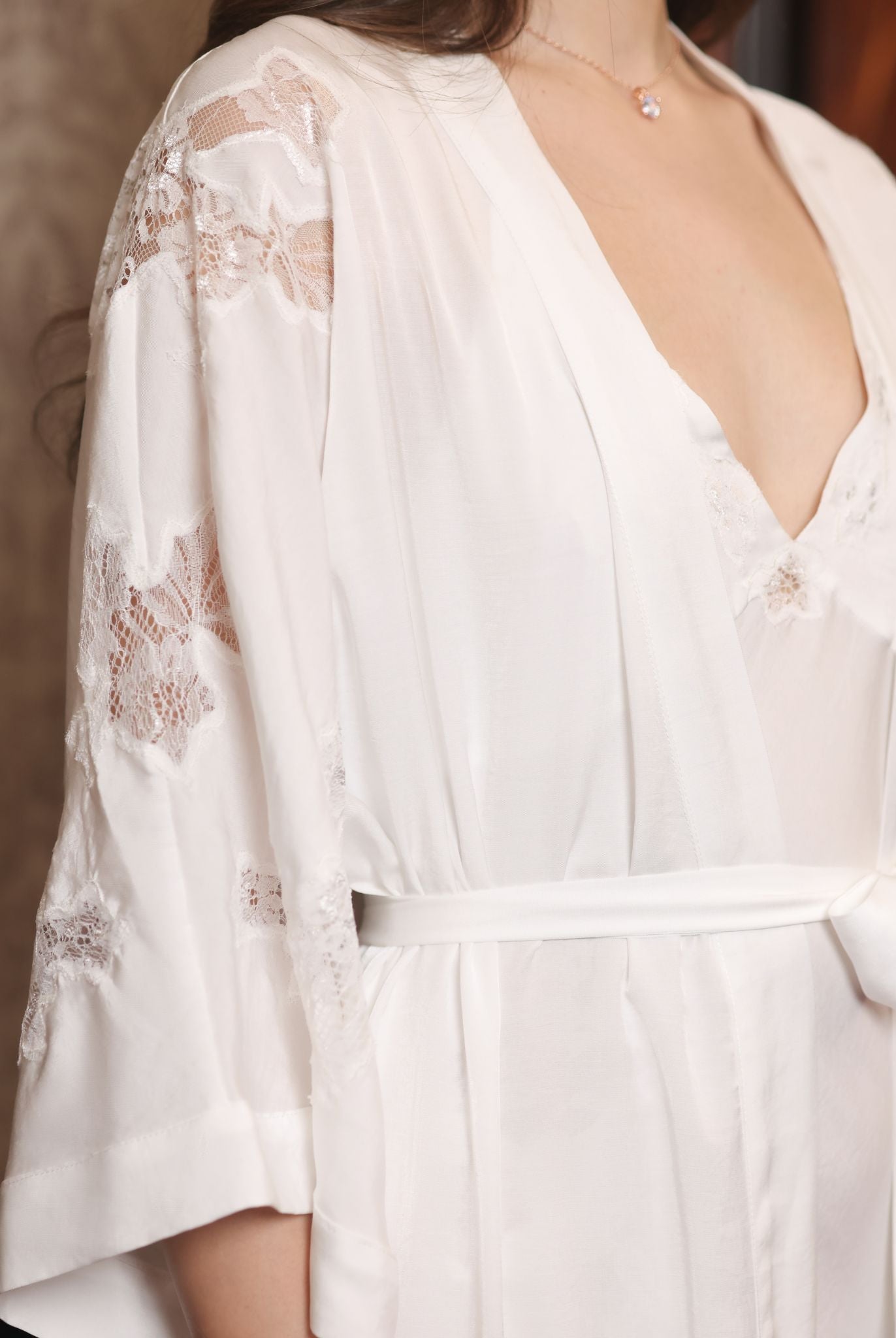 Close-up from head to waist focusing on the intricate lace textures and the delicate artistry of the sleeves.