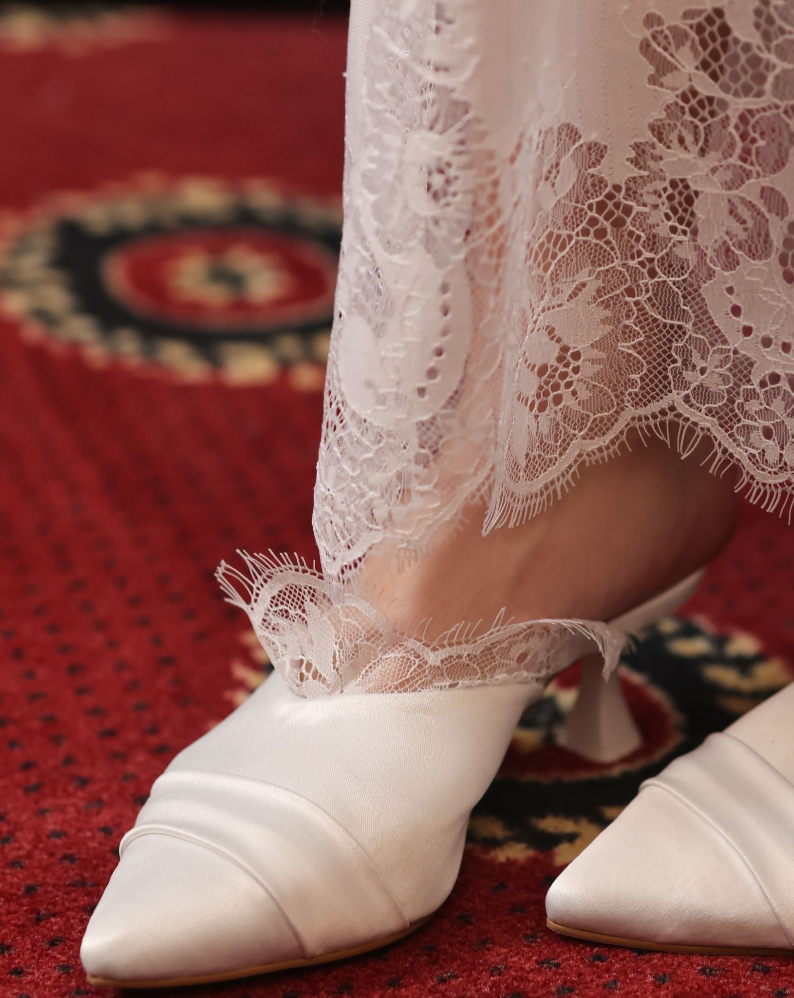Macro shot of the intricate lace detailing at the hem, showcasing the premium craftsmanship of the attire.