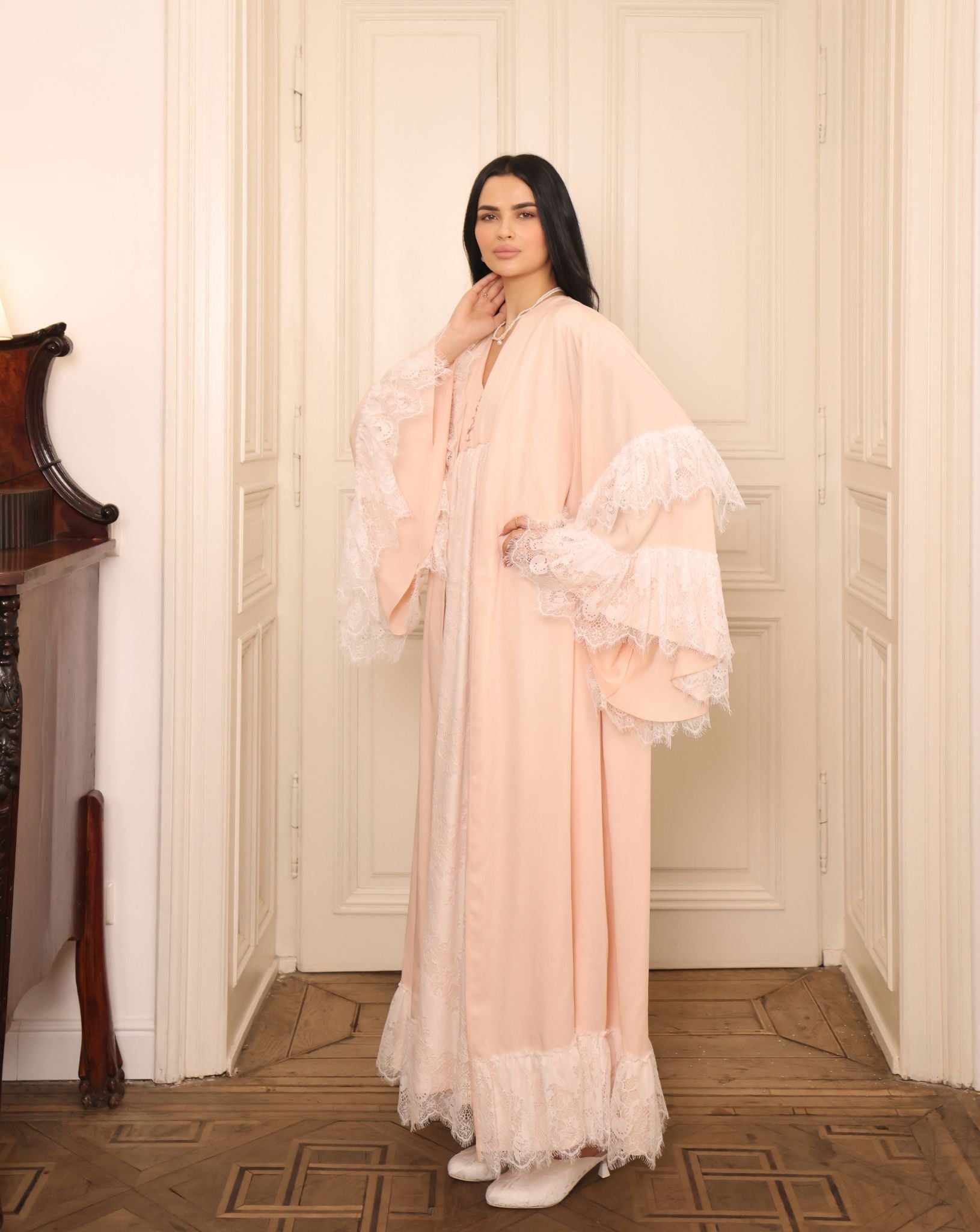 A poised frontal shot of an expecting woman with hands on her belly, highlighting the flattering A-line silhouette.