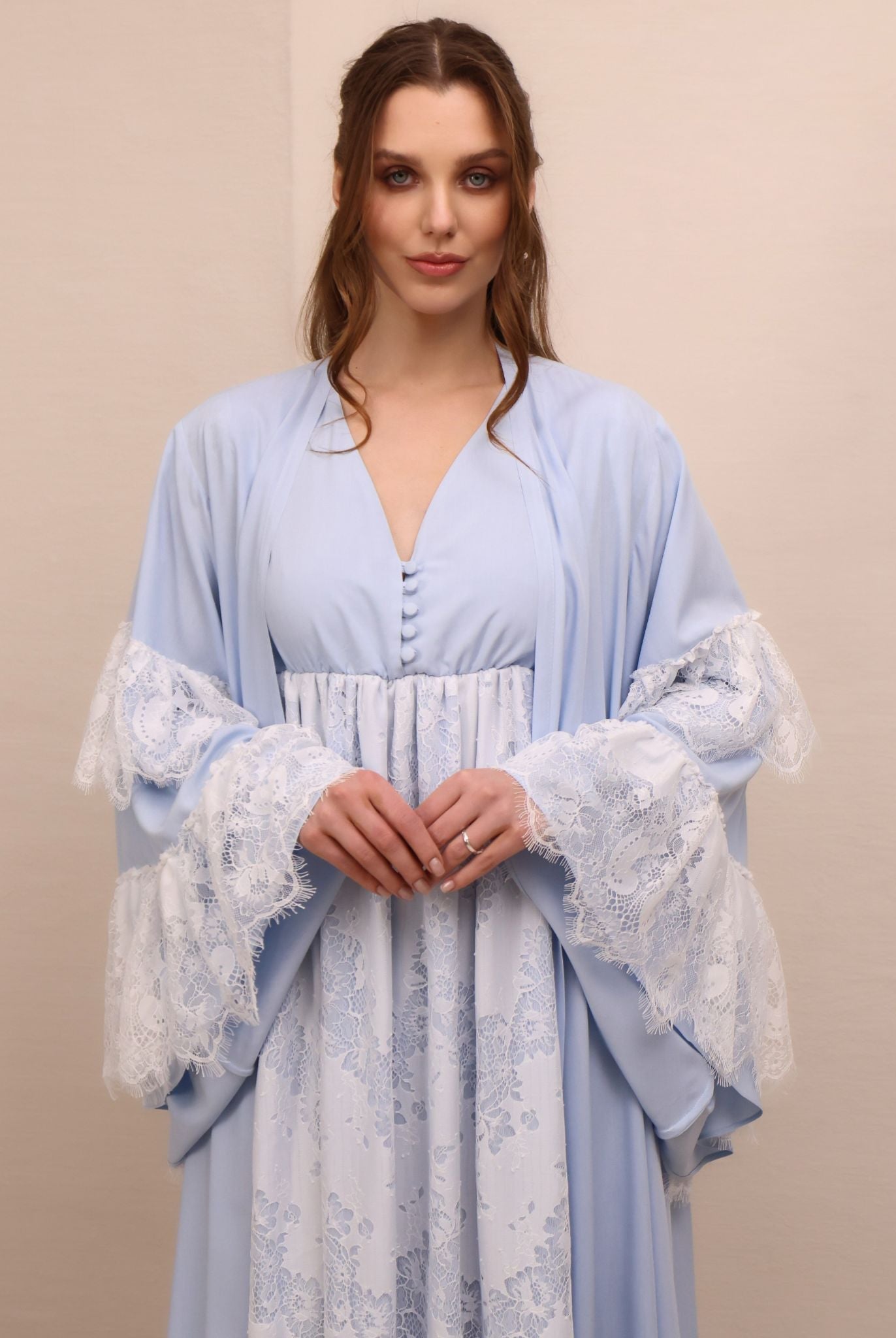 A mid-length shot focusing on the tiered bell sleeves with lace ruffles and the delicate buttoned neckline.