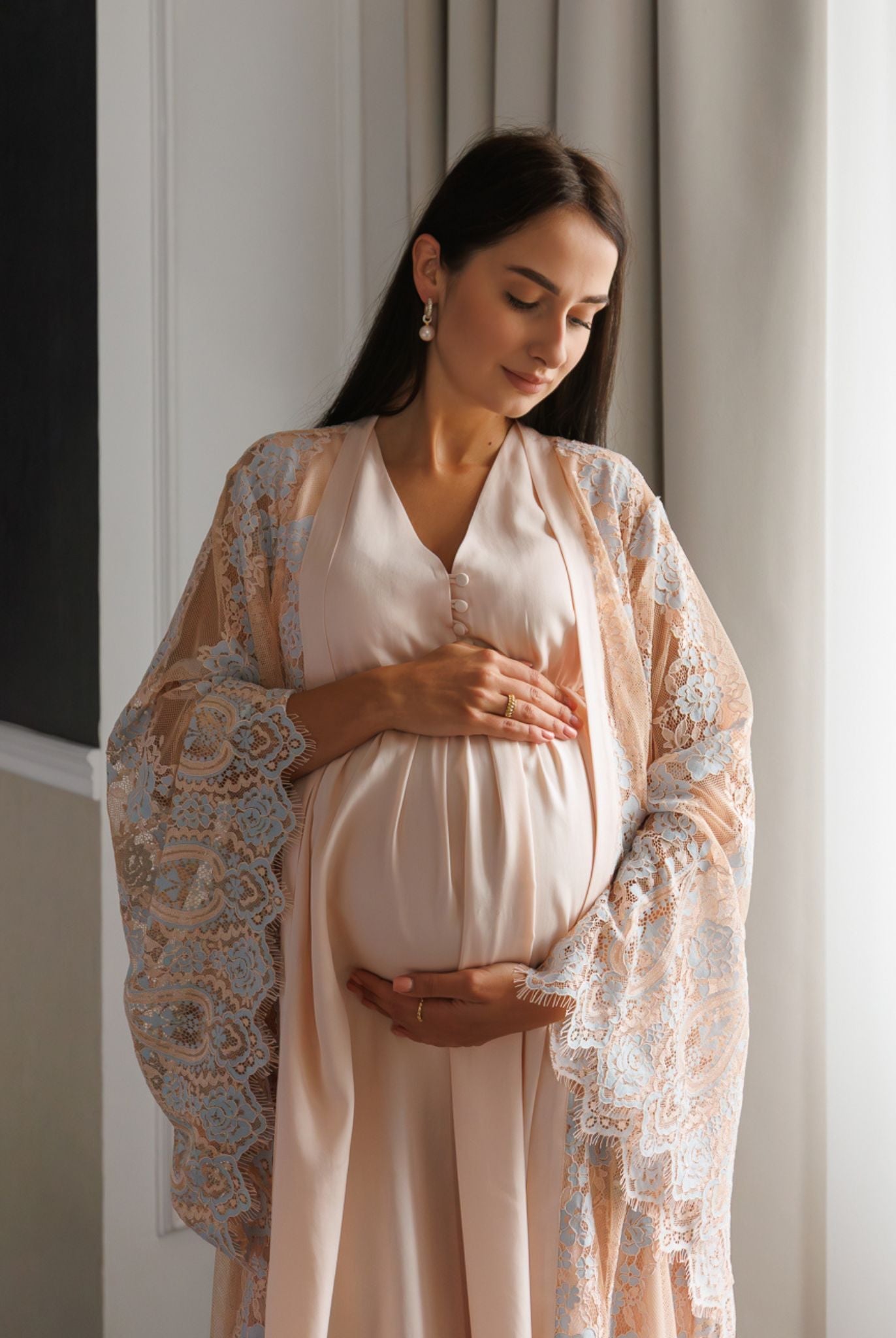 Mid-length shot of a mother-to-be in a lace wrap, highlighting the sophisticated style and easy nursing access buttons.