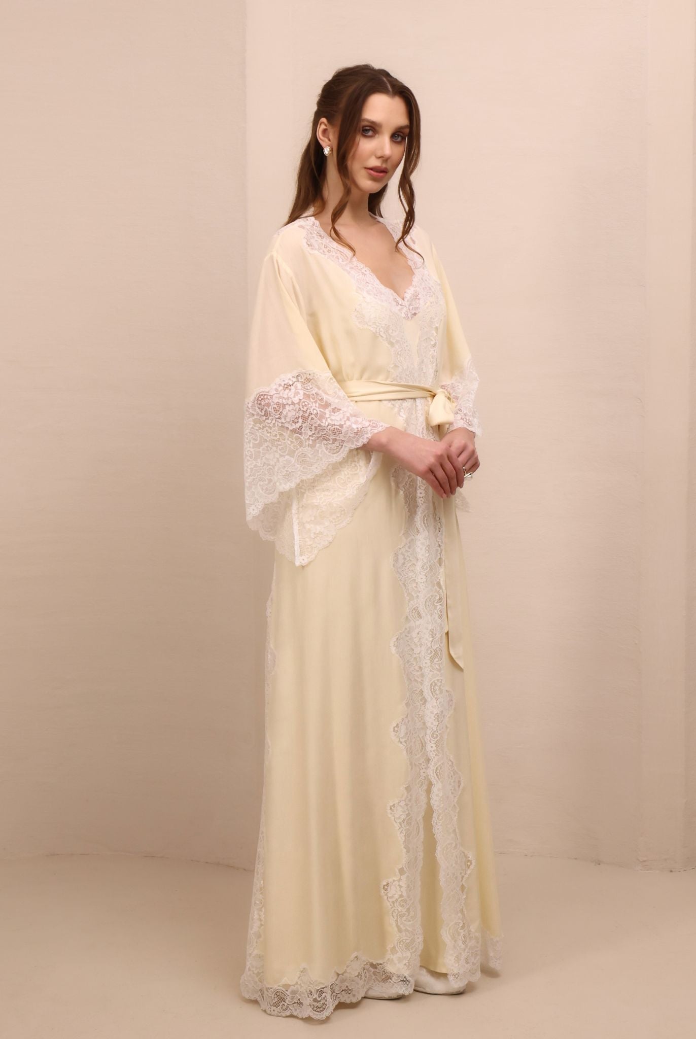 A frontal shot with hands on the waist, focusing on the intricate lace detailing along the flowing sleeves.