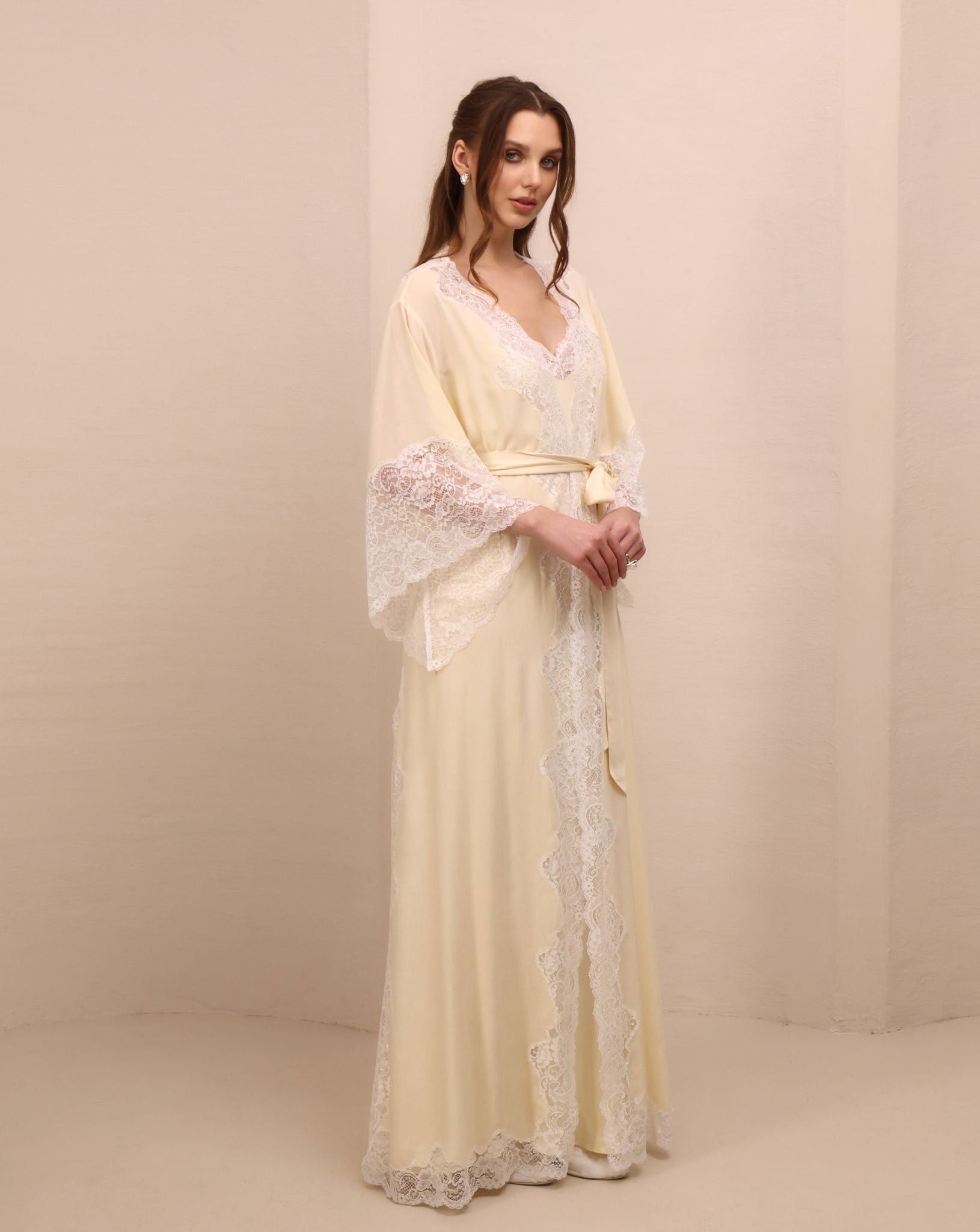 A frontal shot with hands on the waist, focusing on the intricate lace detailing along the flowing sleeves.