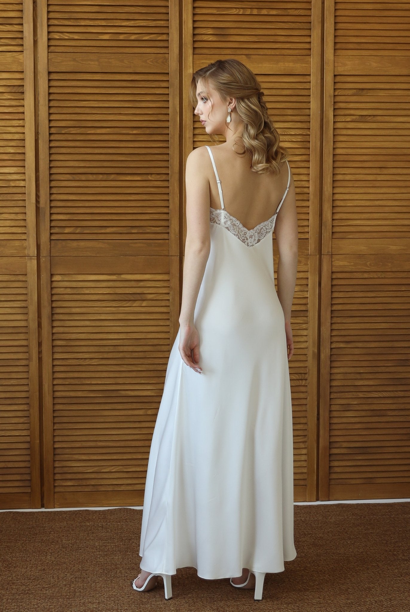 Back view of bride wearing long white nightgown and matching robe