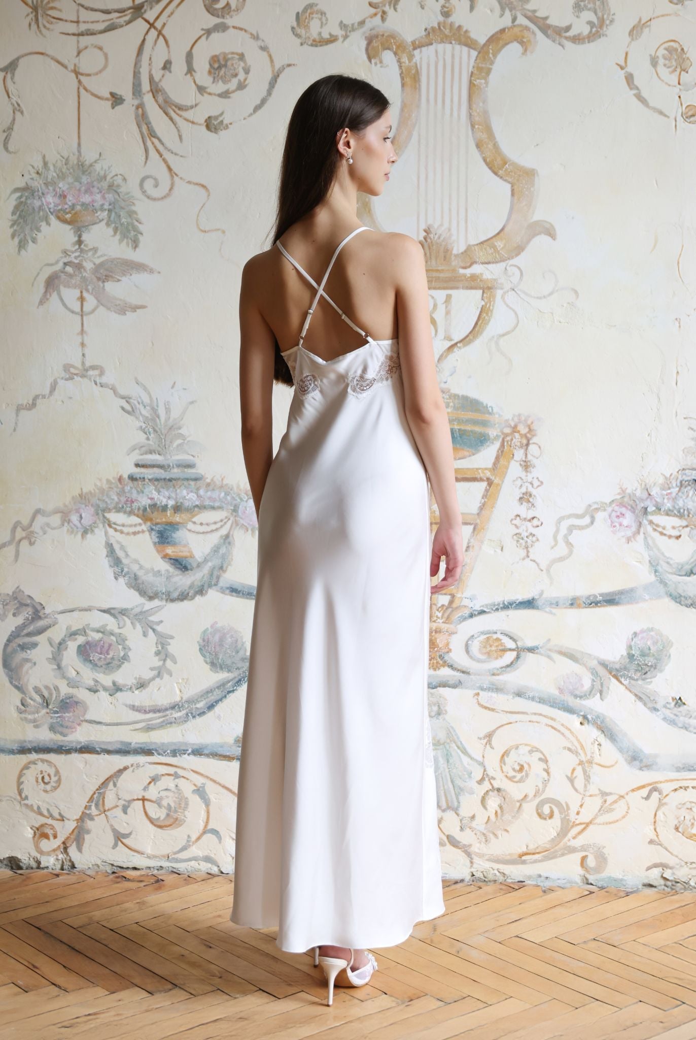Rear view of the white nightgown showcasing the strappy back design with length regulation and graceful floral details.