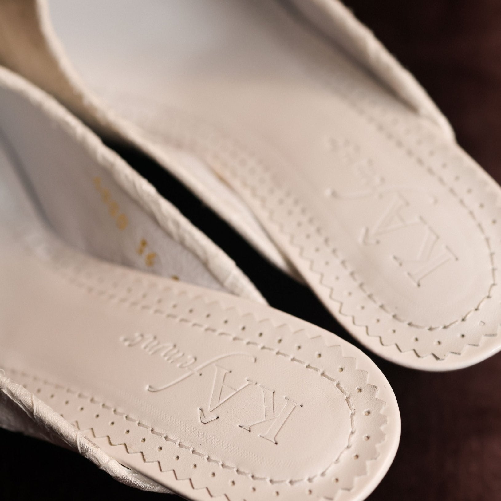 Close-up of the genuine leather insole featuring the brand logo, emphasizing the refined quality of the Slippers.