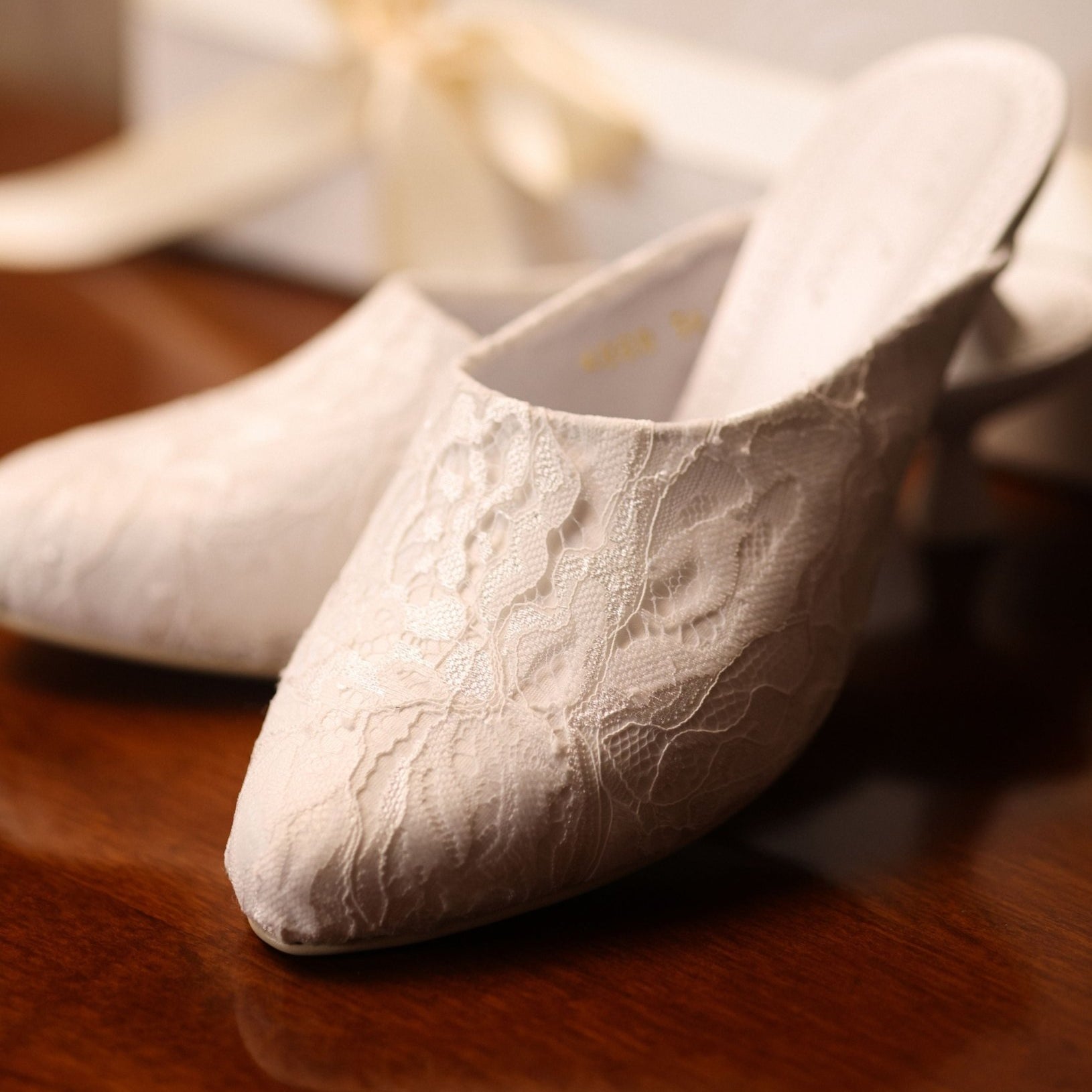 Close-up shot near the packaging, focusing on the carefully balanced elements and the soft lace adornment.