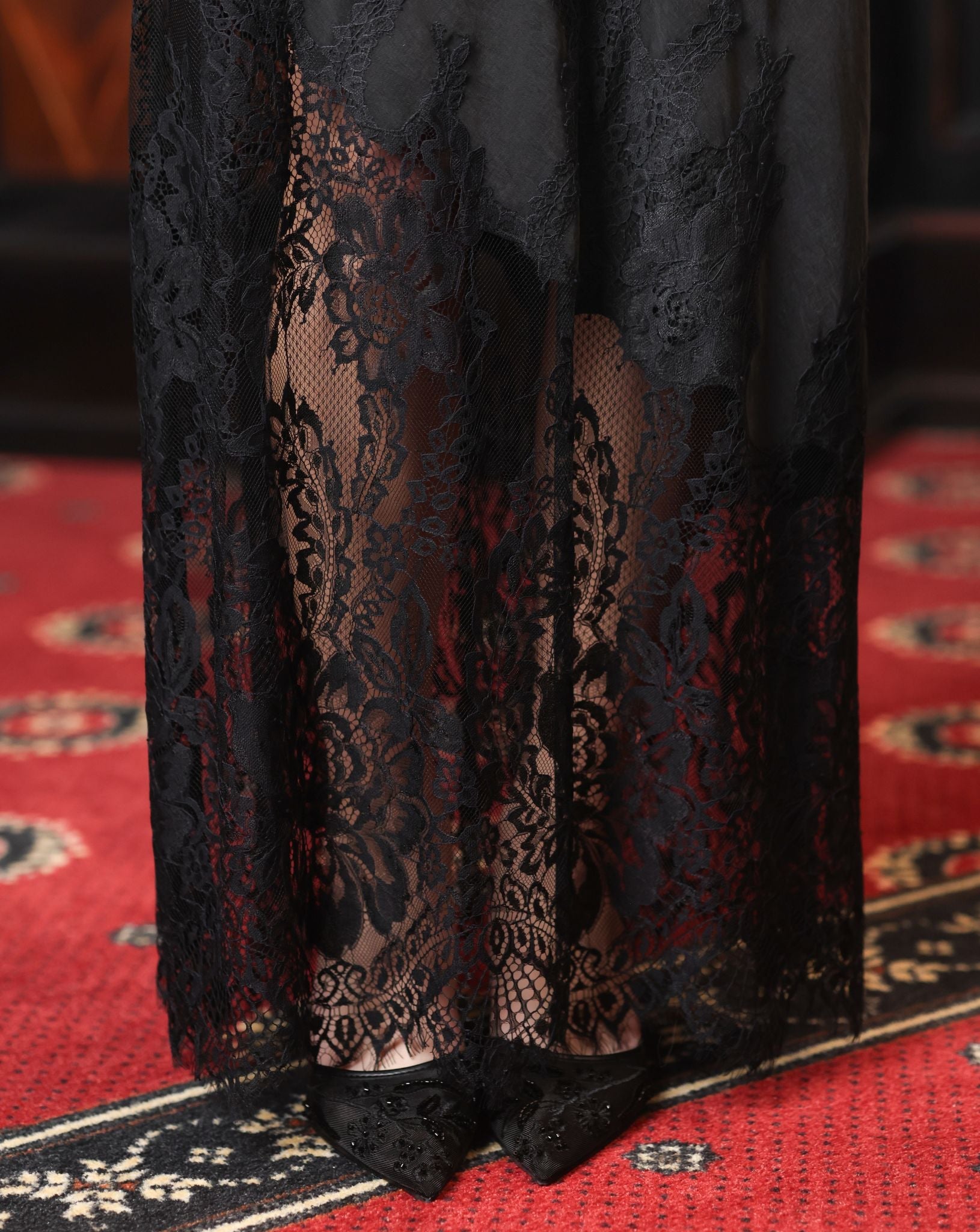Detailed view of the lower nightgown, showcasing the artistic lace border and the richness of the fabric.