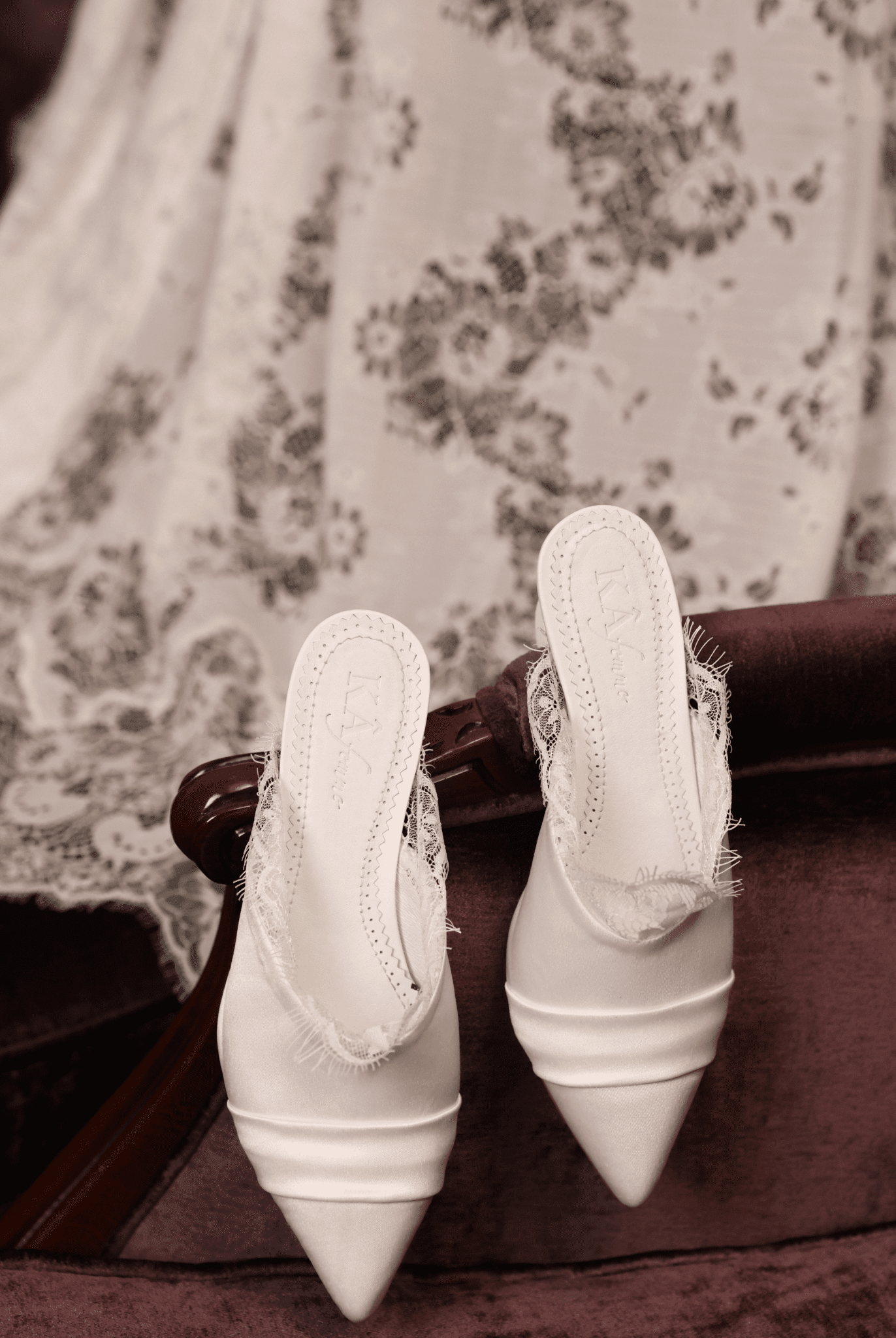 Creative shot of the Heeled Satin Slippers hanging on a chair, surrounded by delicate lace for a poetic home vibe.