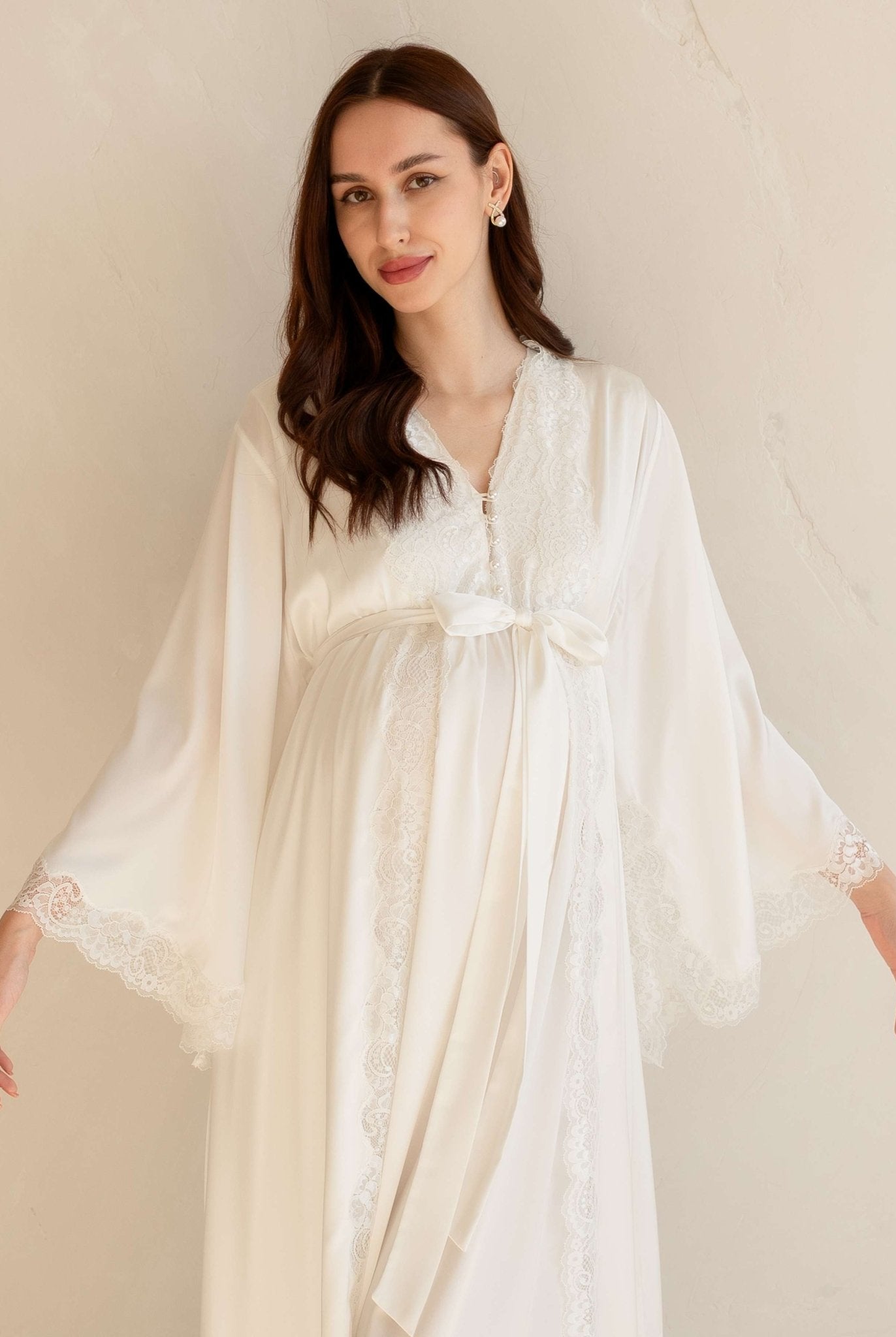Mid-length view of a white maternity ensemble featuring