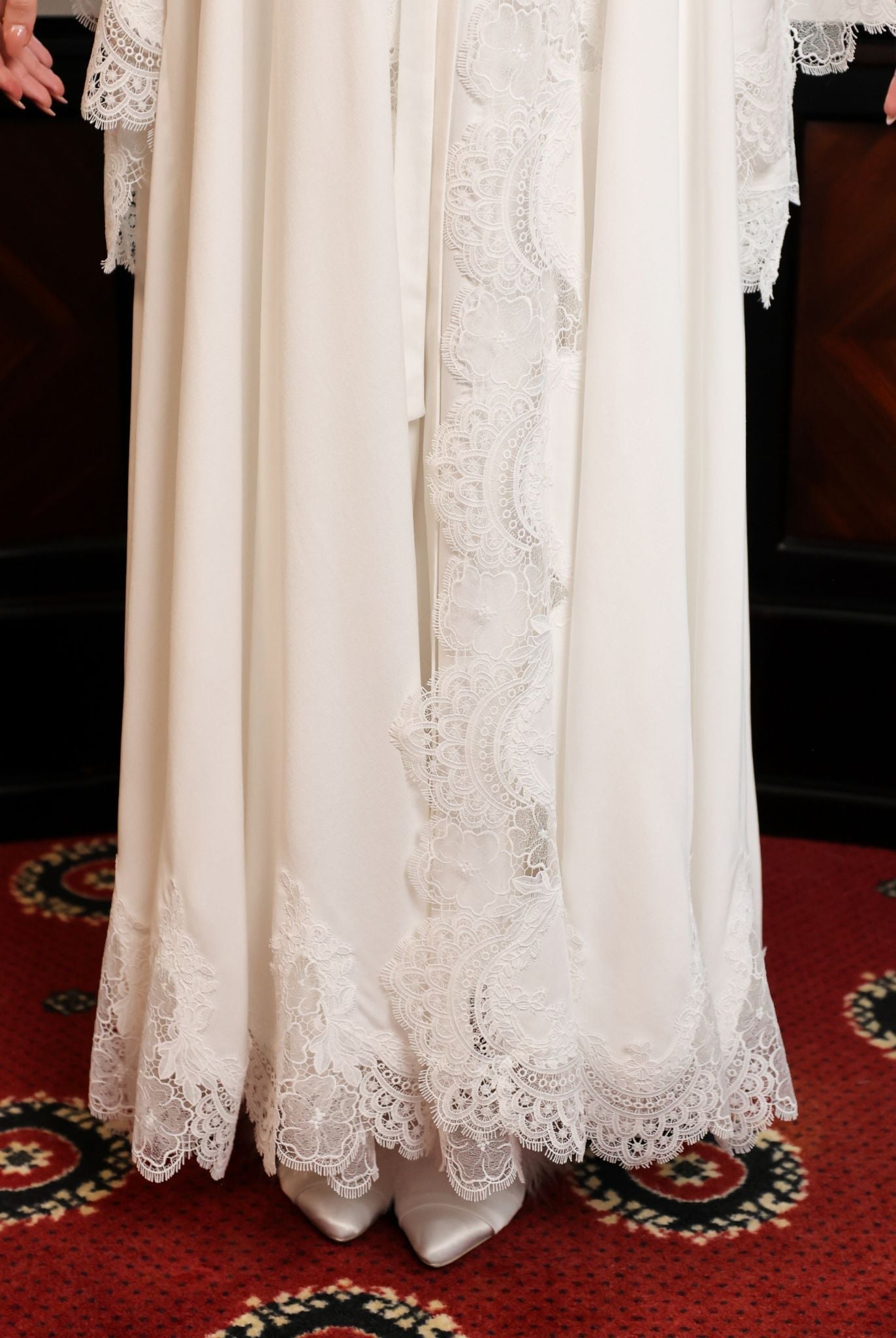Close-up of the lower part of the ensemble, highlighting the quality of the lace and the sweeping length.