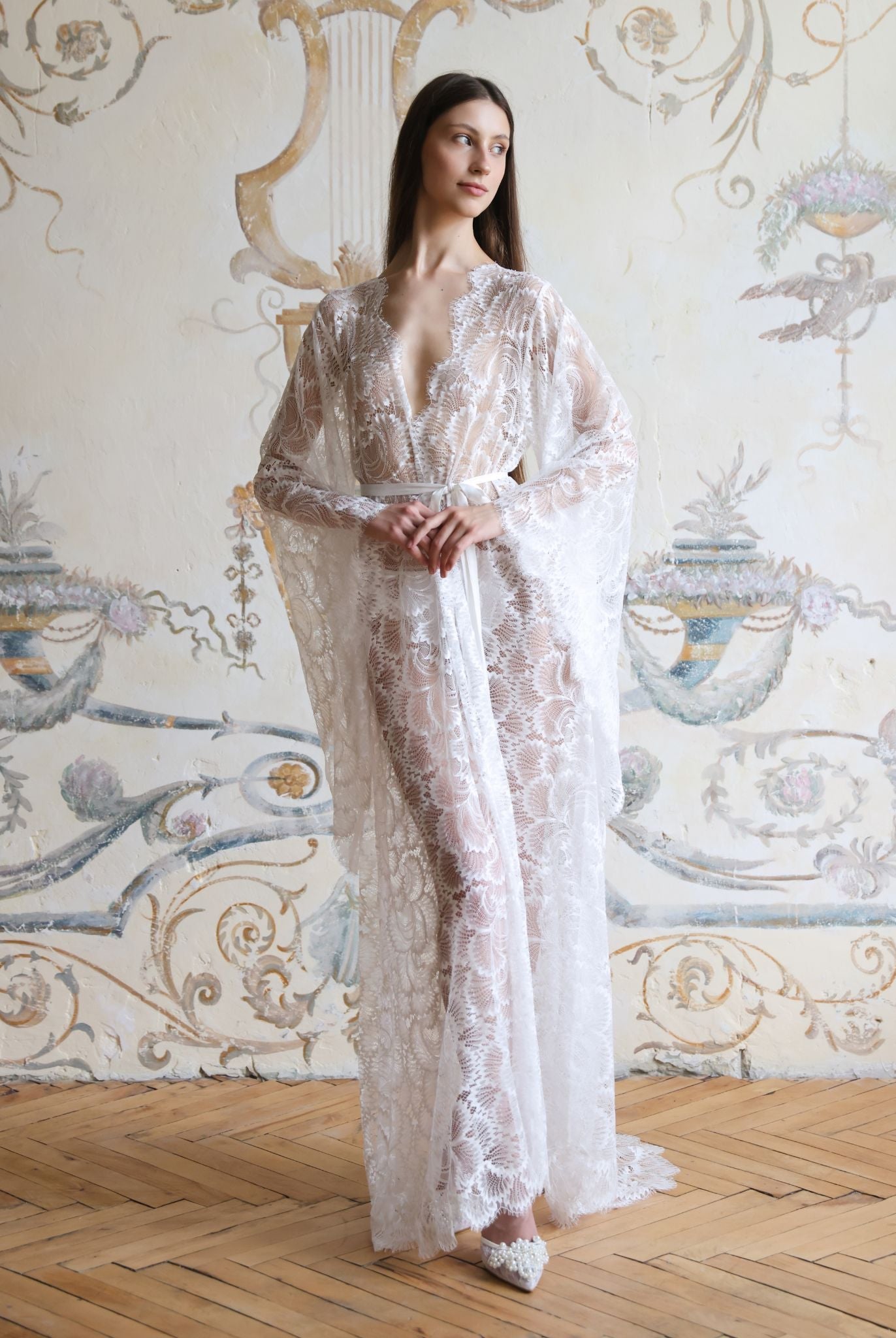 Full-length front view of the floor-length white lace robe, emphasizing its regal silhouette and lightweight fabric.