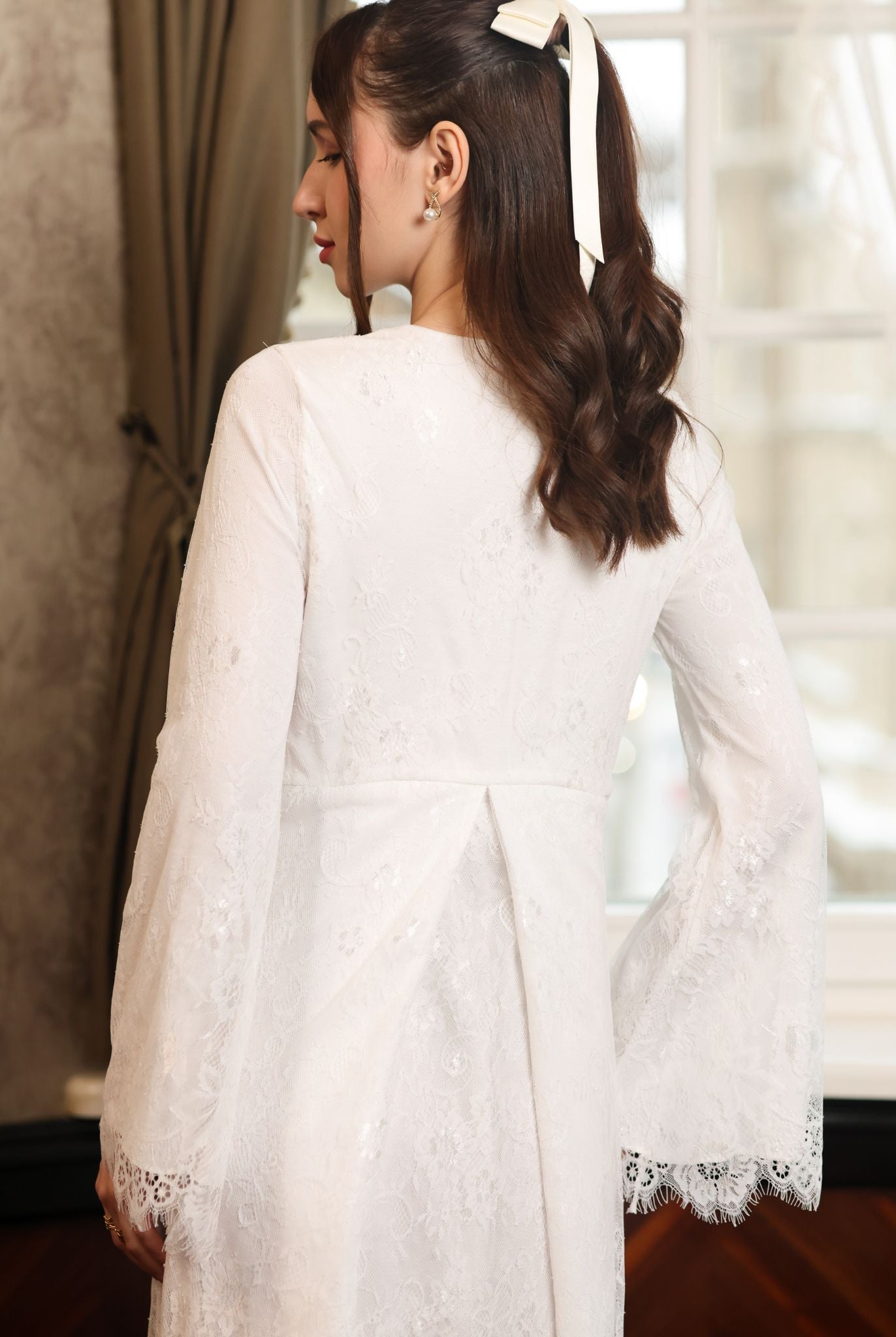 Back perspective of the floor-length lace gown, illustrating the heirloom quality and full coverage of the design.