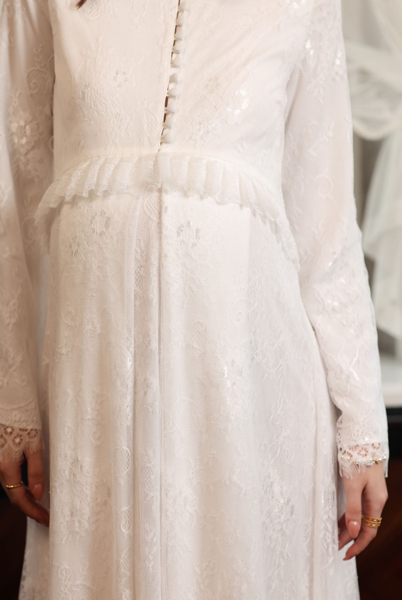 Close-up of the Modest Lounge Dress bodice, featuring satin buttons for discreet nursing access and a ruffled waist.