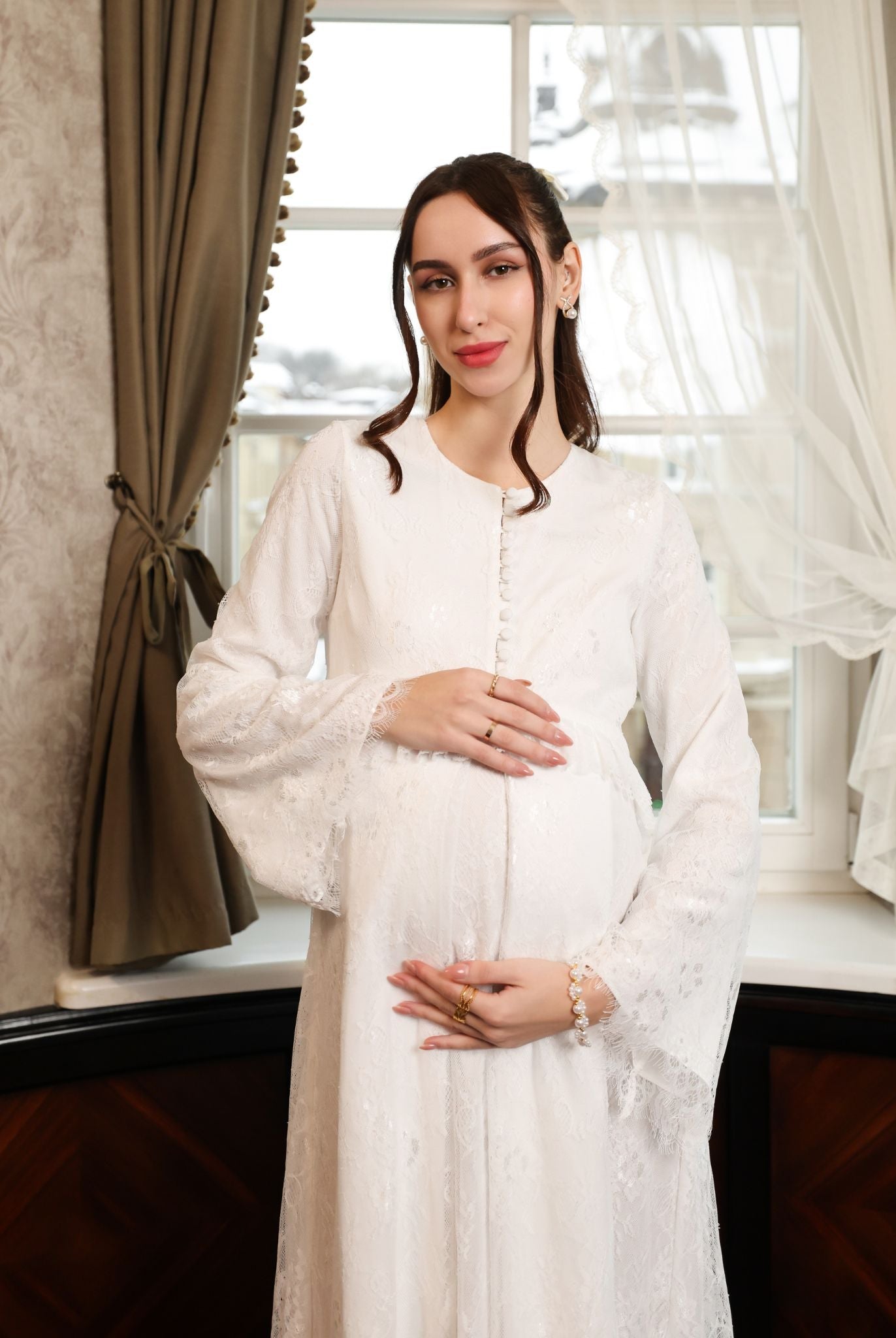 Mid-length shot of an expecting woman, showcasing the soft, flattering shape and heirloom feel of the attire.