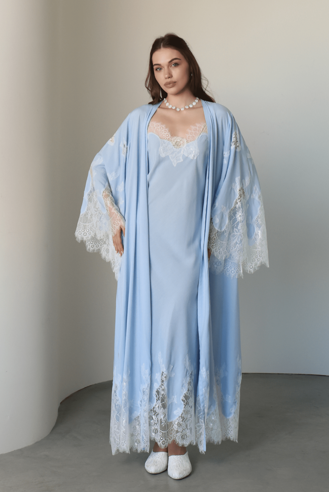 Frontal view of the attire with hands on hips, highlighting the exquisite lace detailing on the wide, elegant sleeves.