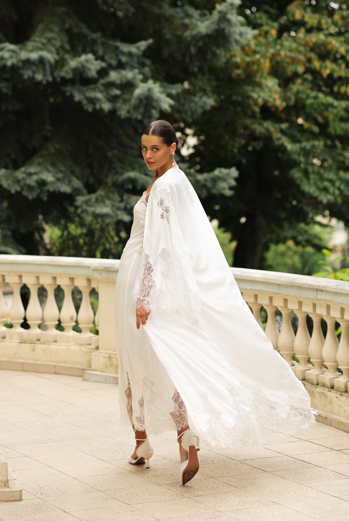 Rear view of the flowing cotton wrap in motion, emphasizing the timeless style and graceful floor-length silhouette.