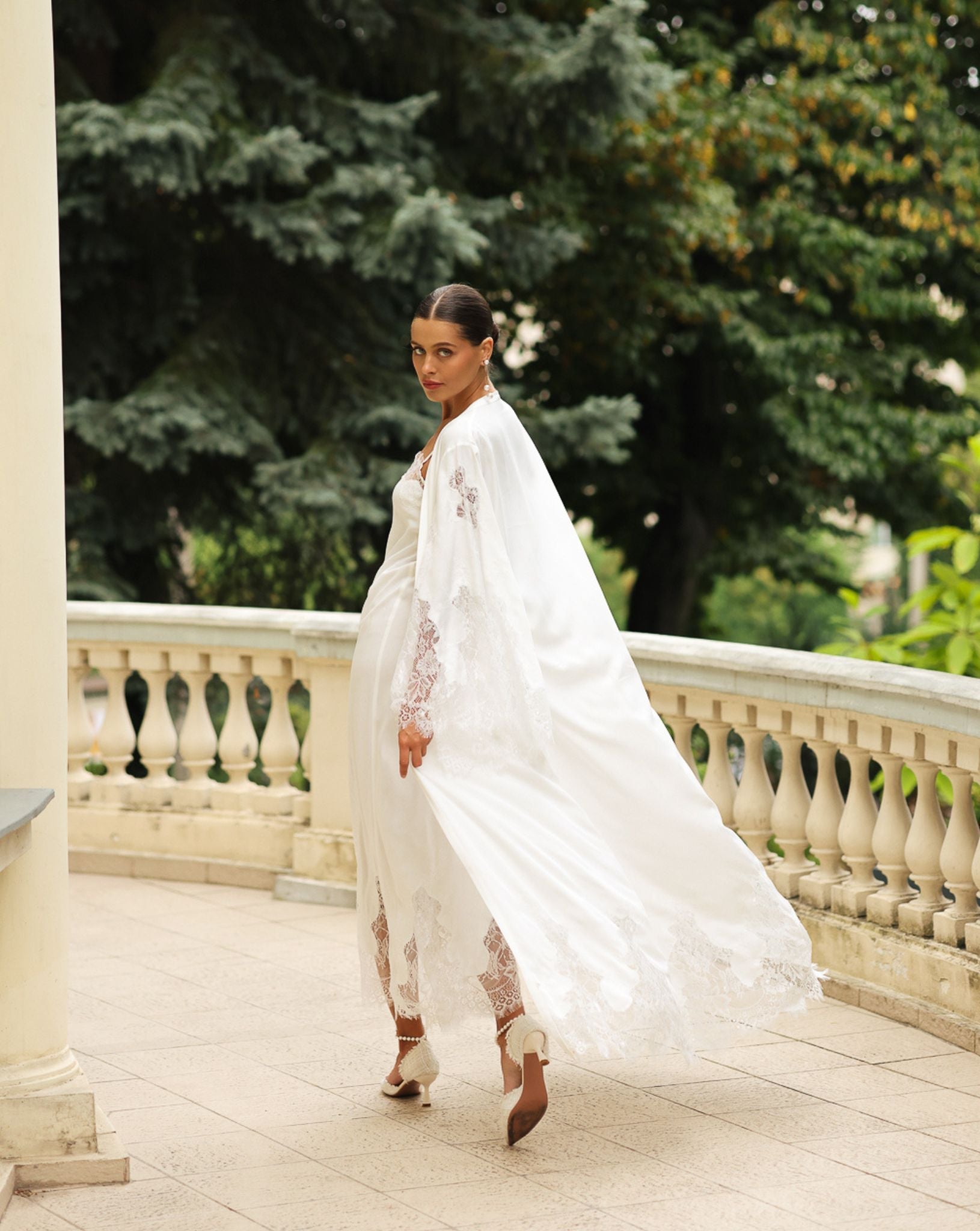 Rear view of the flowing cotton wrap in motion, emphasizing the timeless style and graceful floor-length silhouette.