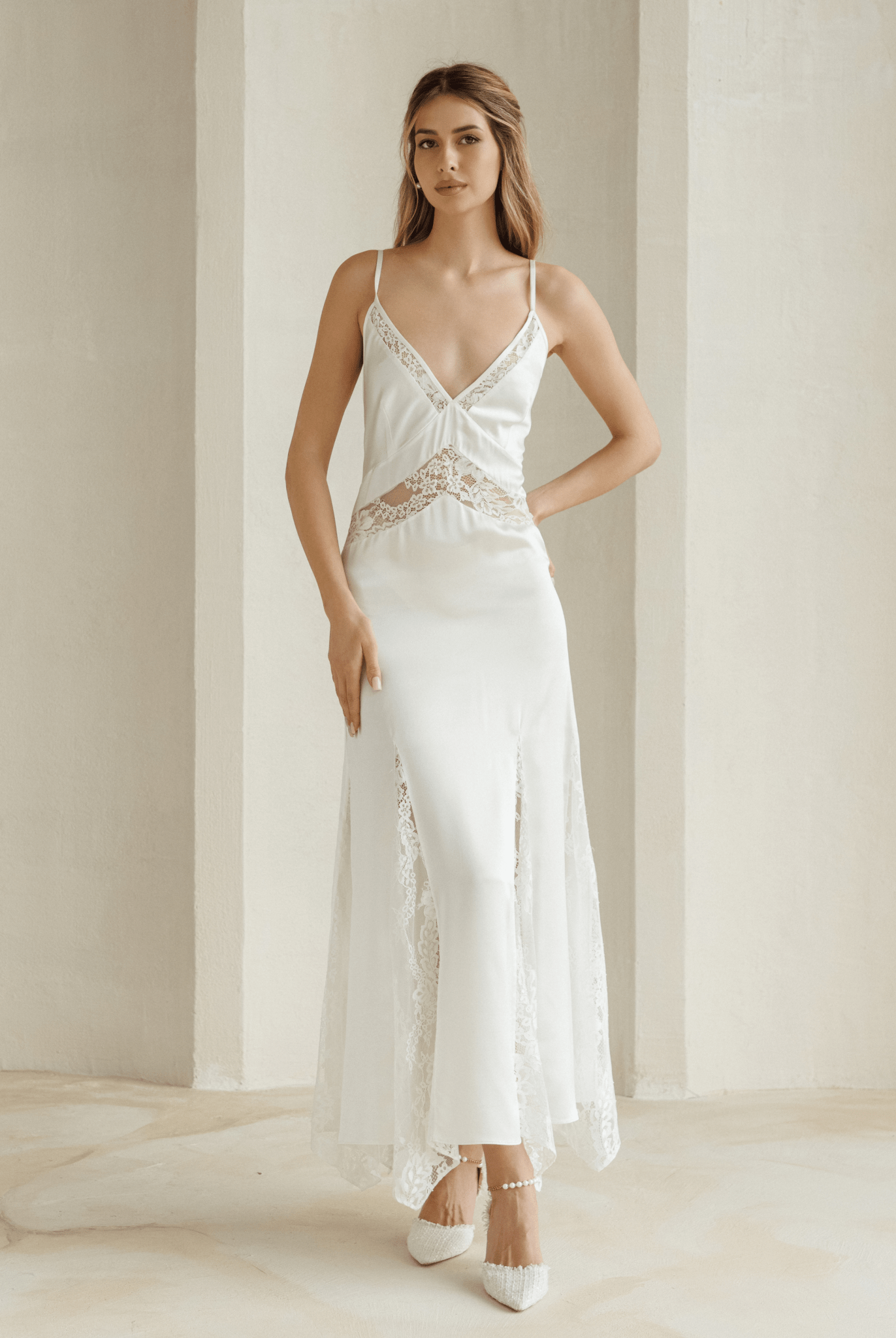 Full-length ivory nightgown with lace bust detail modeled in minimalist room