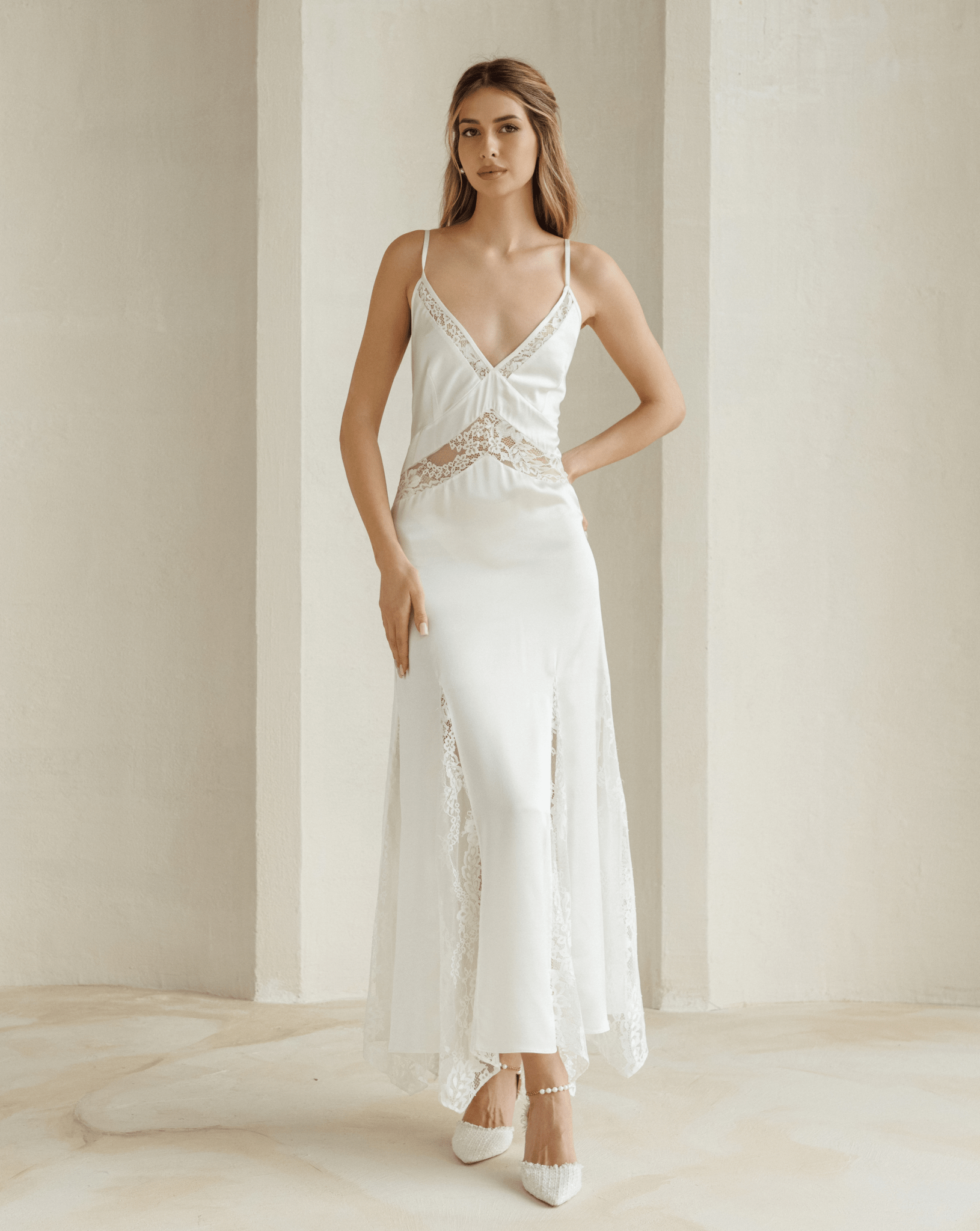 Full-length ivory nightgown with lace bust detail modeled in minimalist room