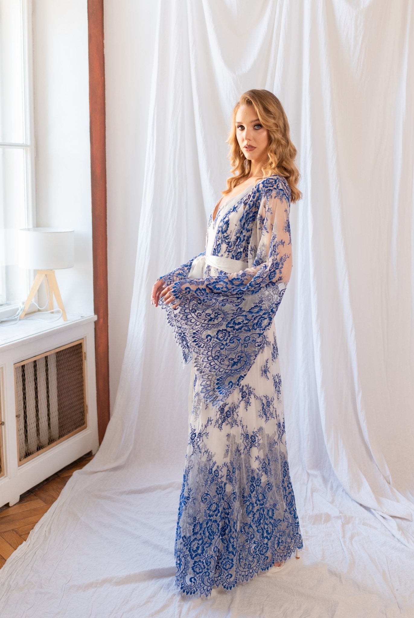 Model showing side of flowing blue and white lace robe