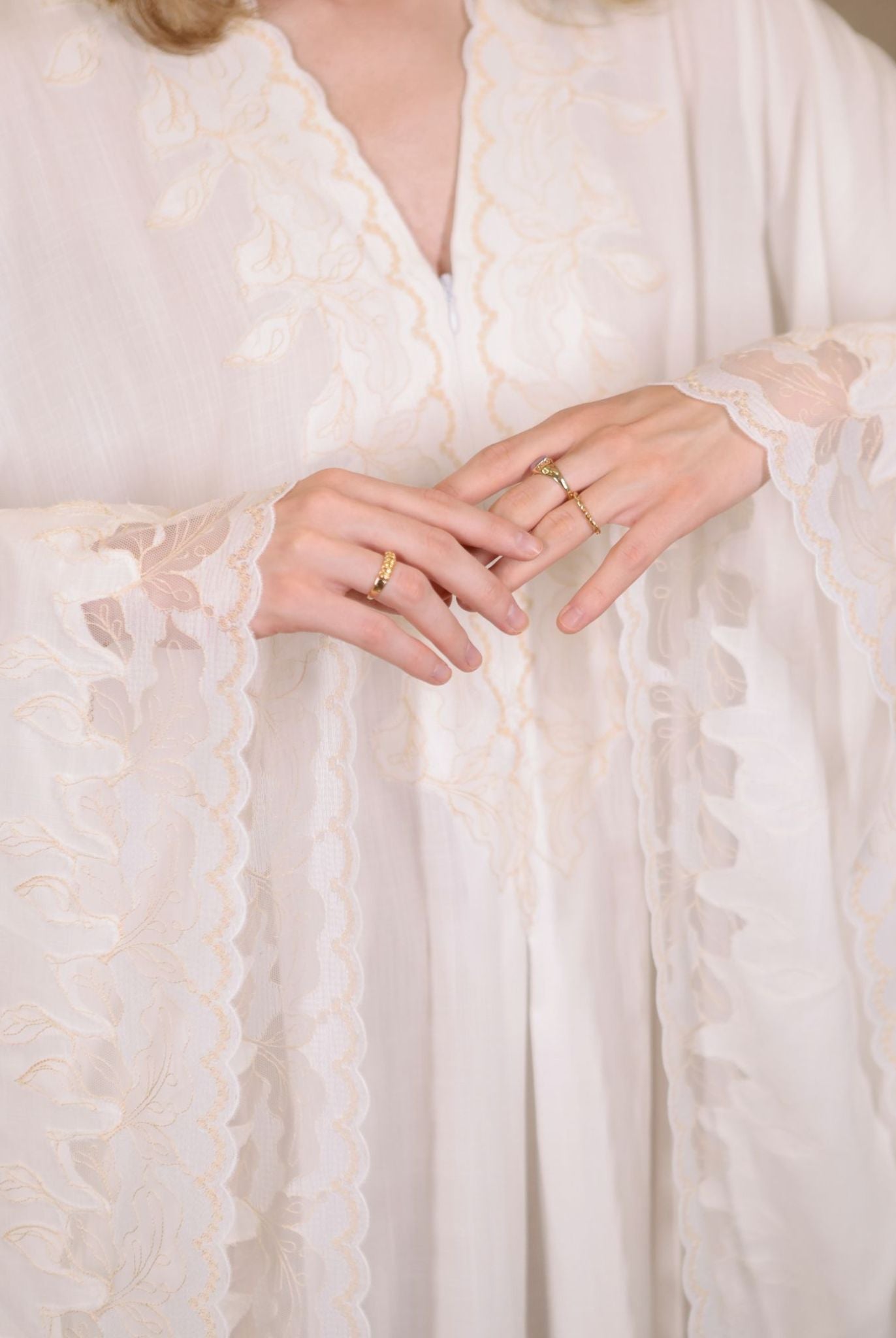 Close-up of the intricate lace detailing on the sleeves, showcasing the refined craftsmanship and feminine touch.