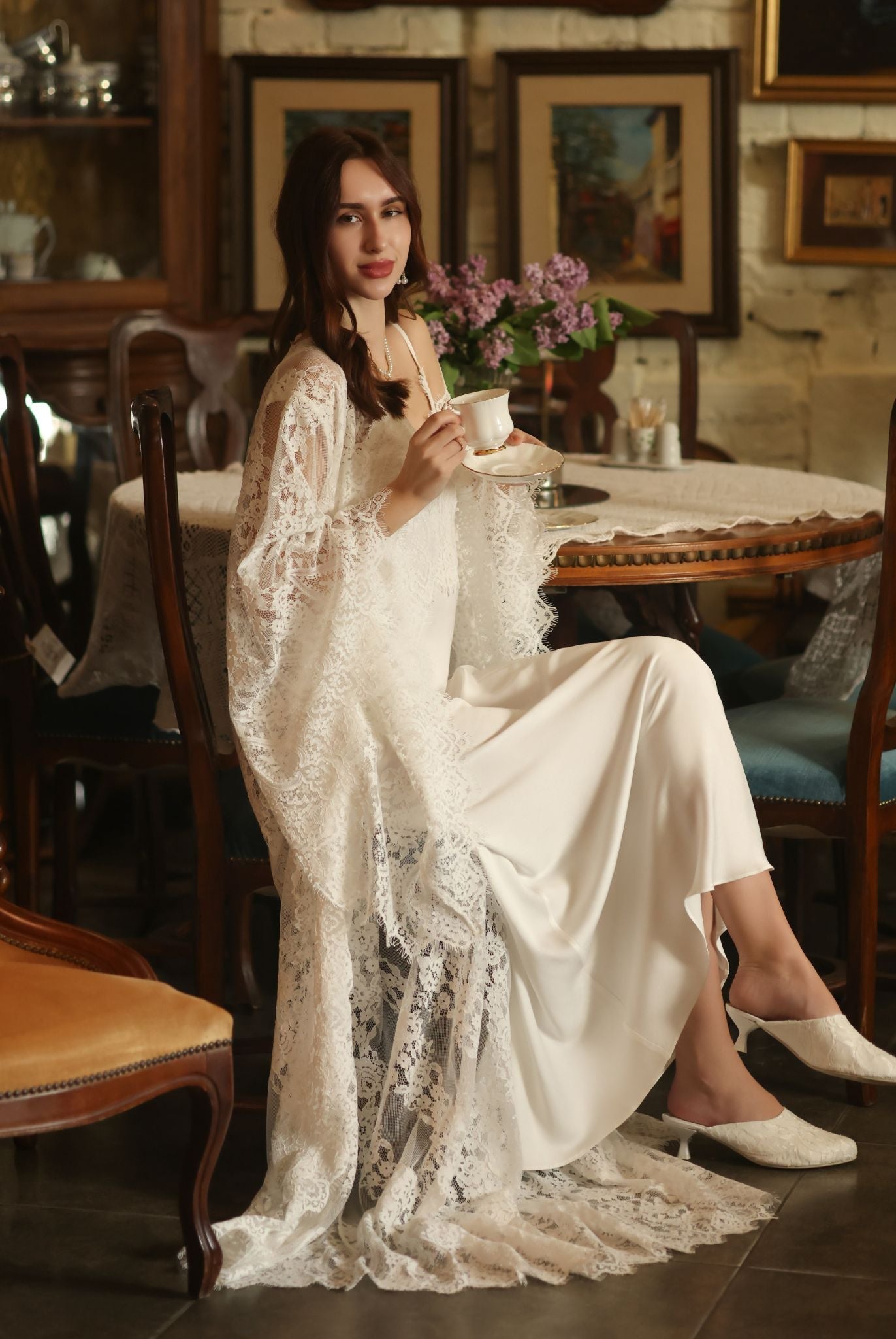 An artistic photograph of a woman sitting and drinking coffee, capturing a relaxed morning ritual in nightwear.