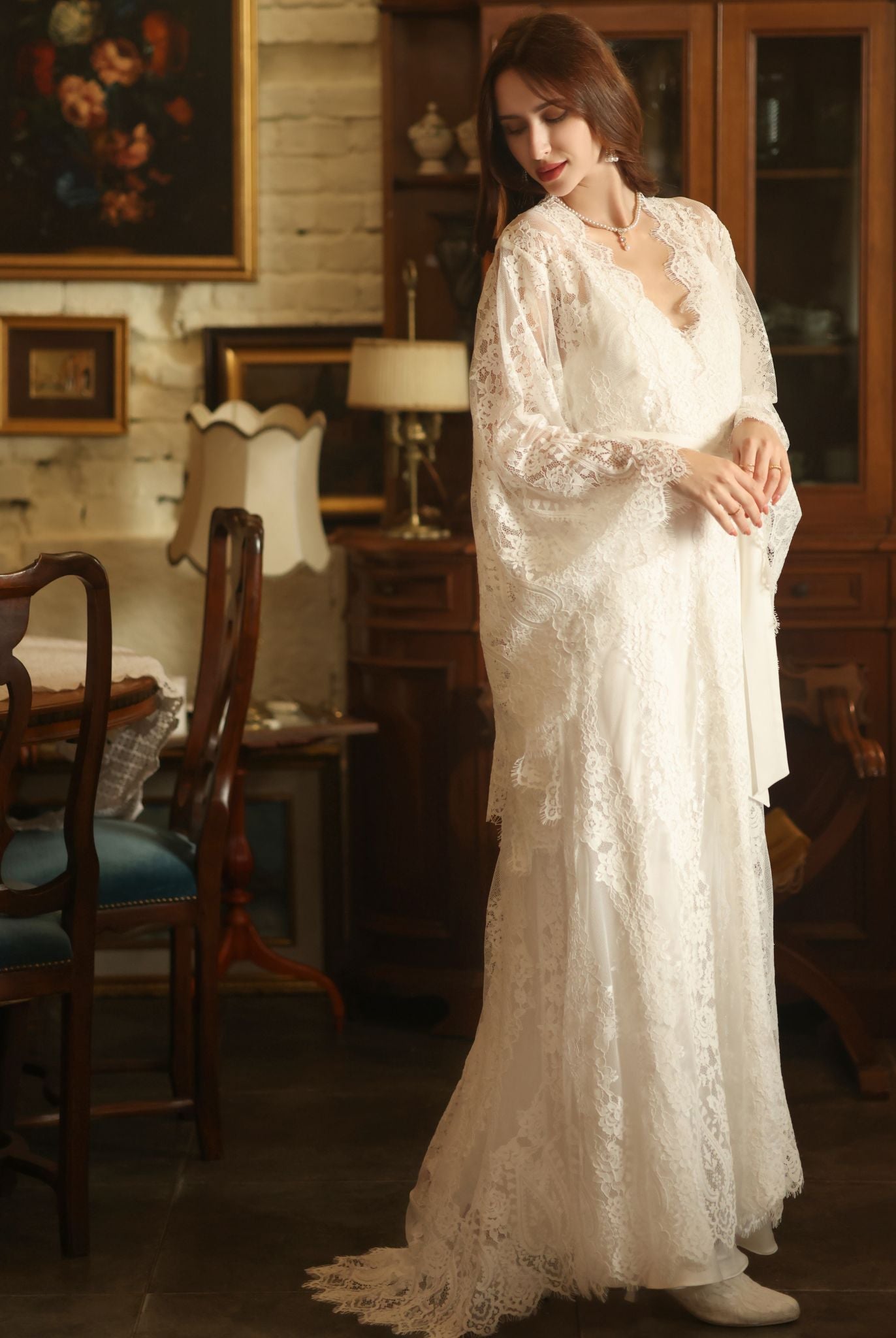A full-length shot of the woman looking back at the flowing train of the robe, emphasizing its dramatic length.