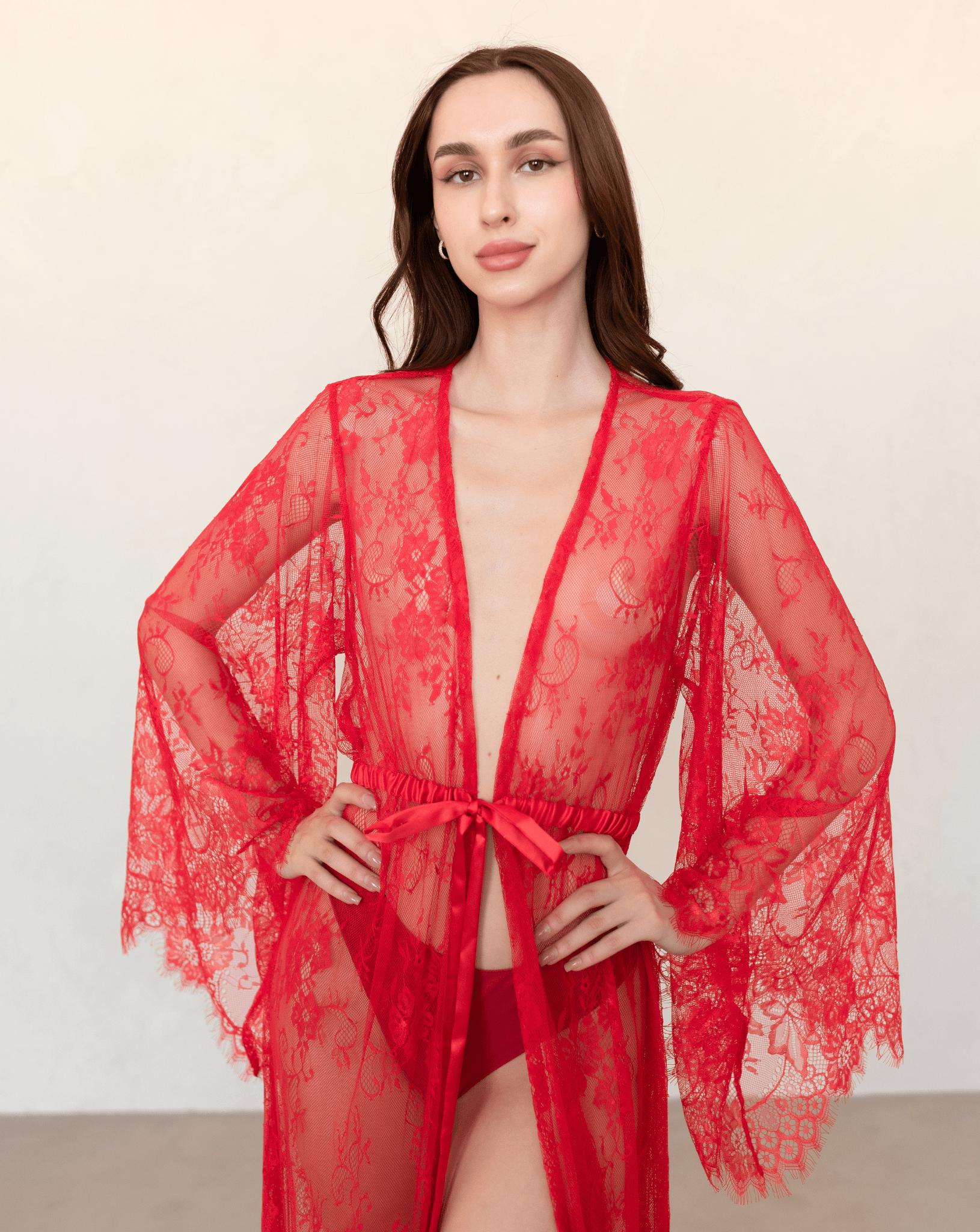 Close-up of red lace robe showing neckline and sleeve detail, capturing romantic texture.