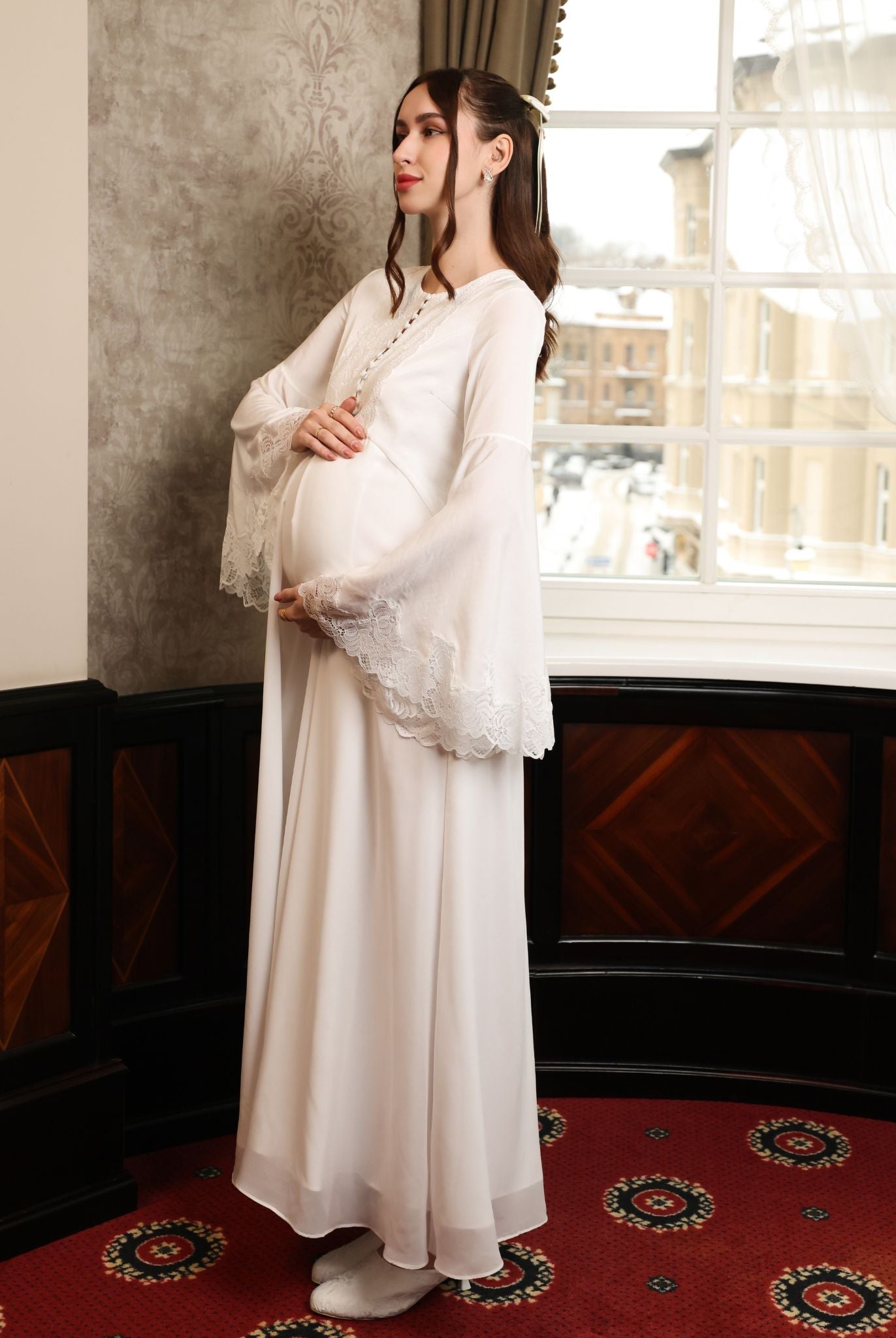 Side perspective highlighting the softly structured upper part and how the dress flatters a maternity silhouette.