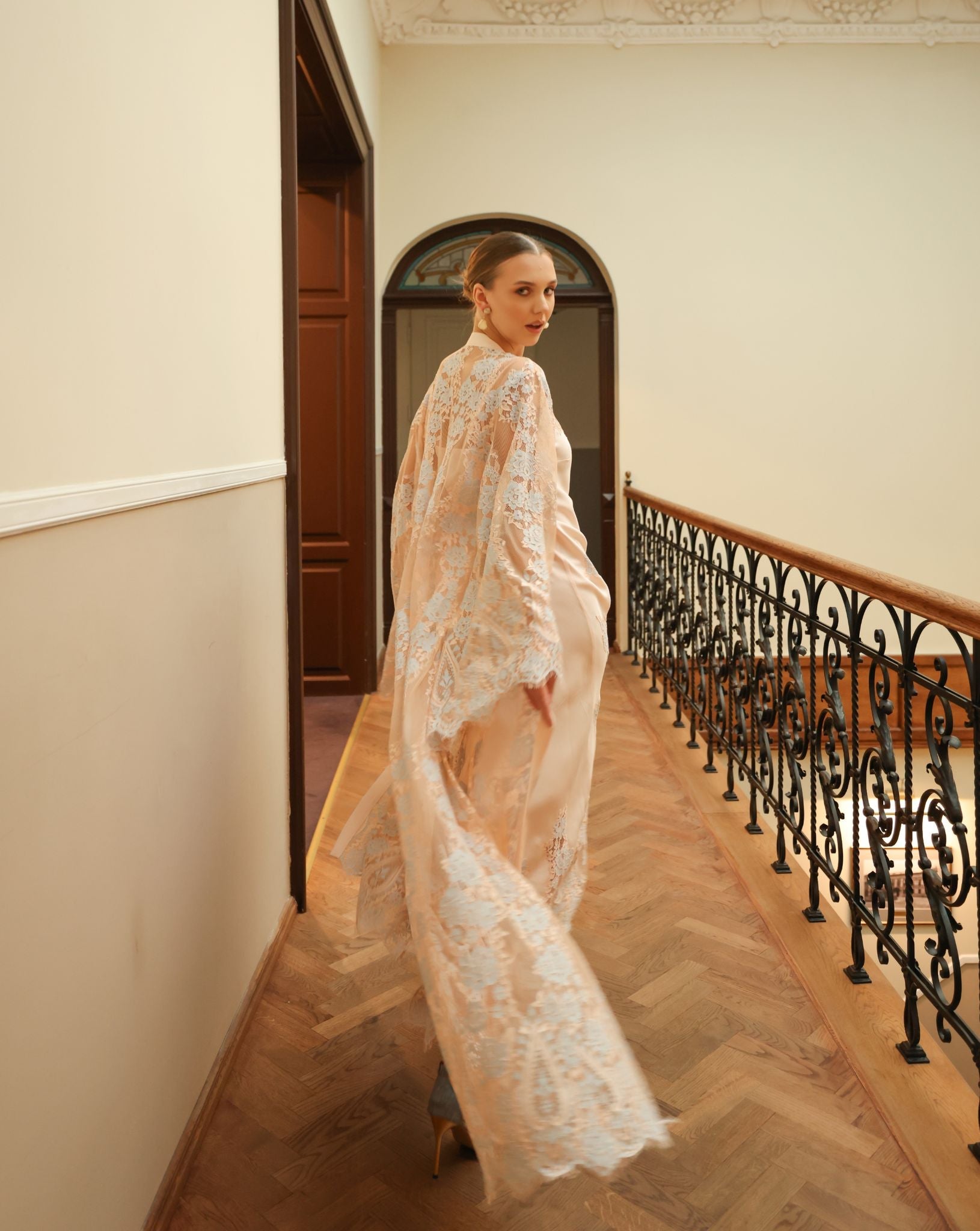 Rear view showing the graceful drape of the floor-length robe, emphasizing its light and airy structure.