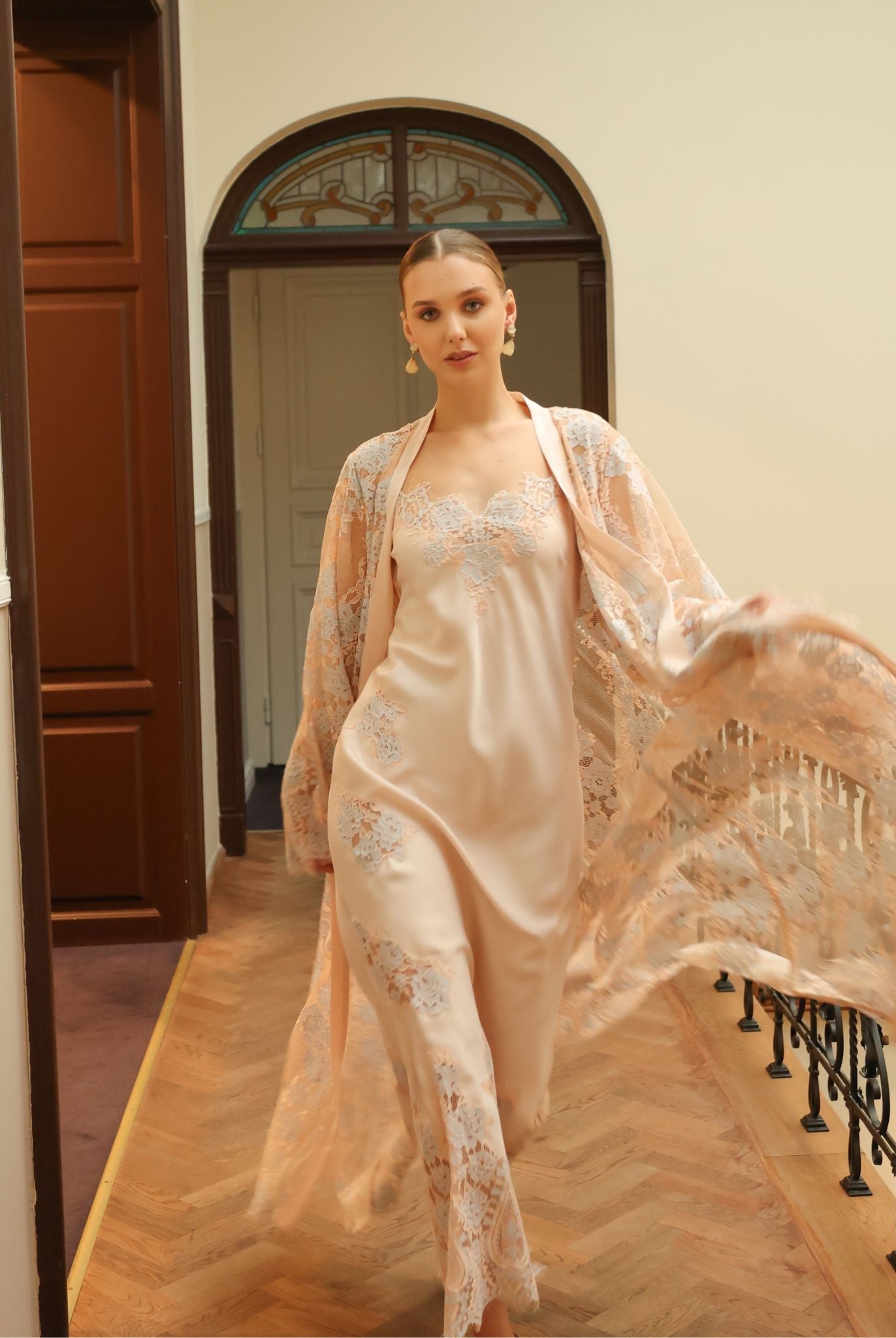 Dynamic shot of a flowing lace robe in motion, capturing the luxury and artistic charm of the ensemble.