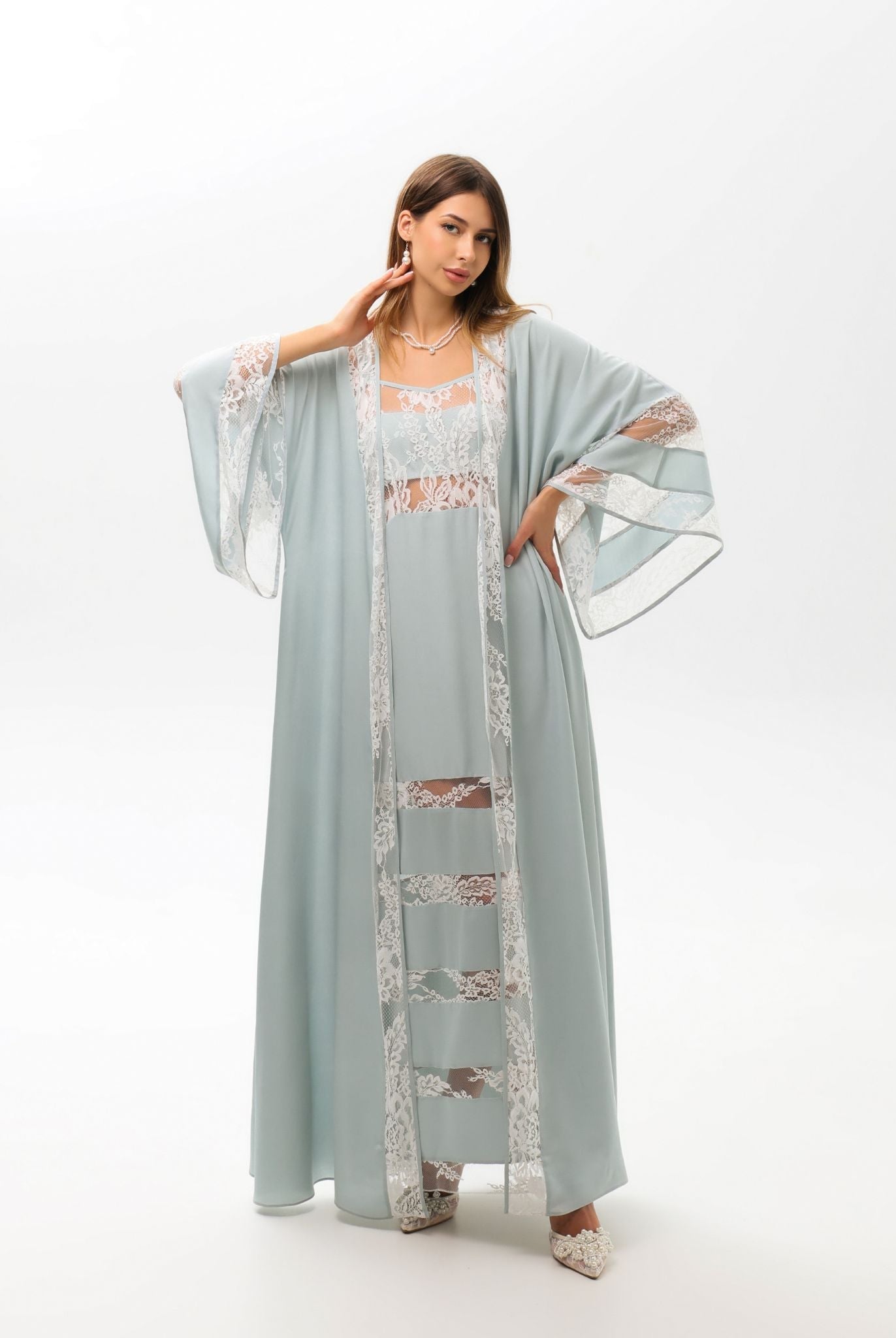 A sophisticated pose showcasing the delicate lace detailing at the sleeves and edges of the attire.