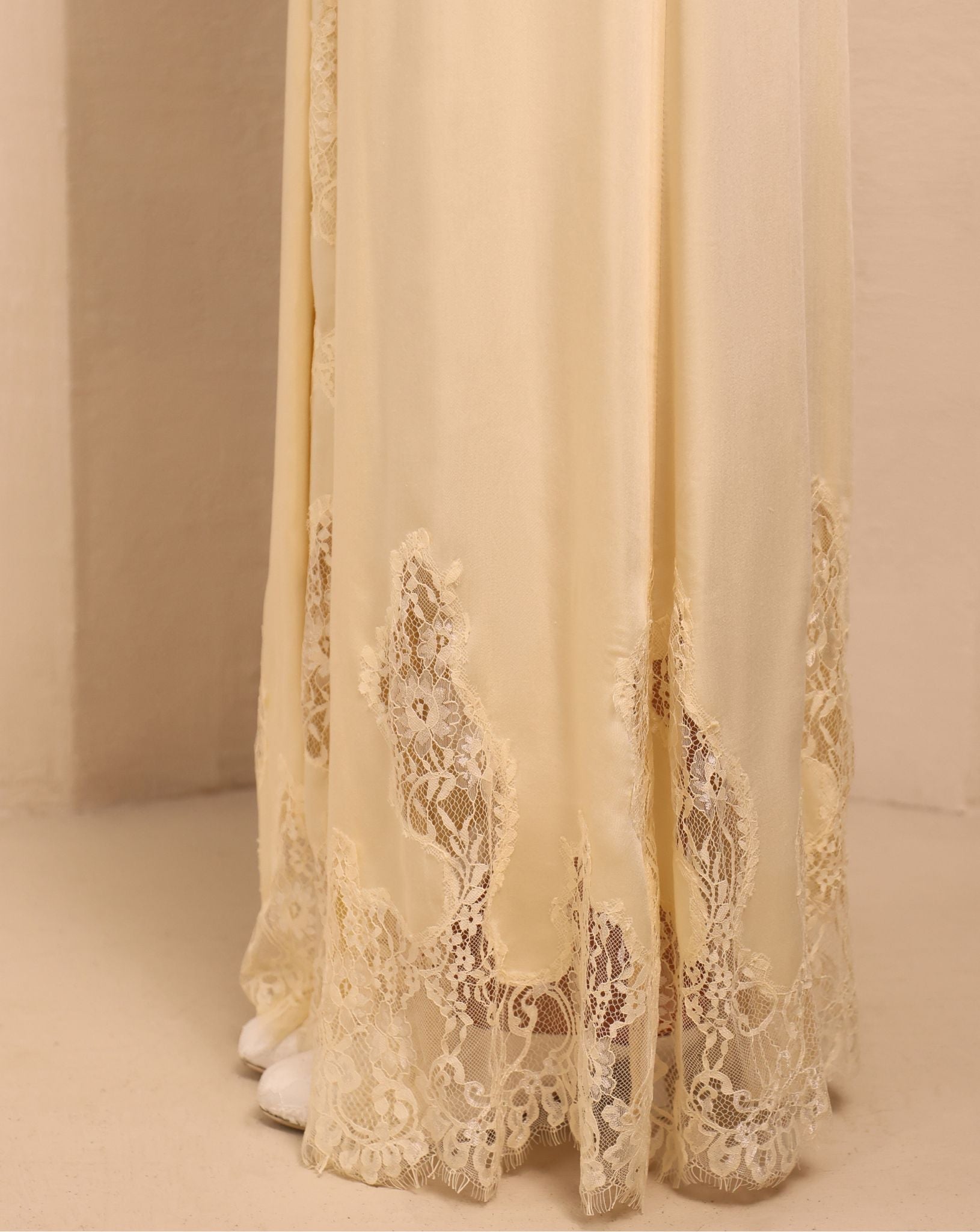 Close-up of the nightgown's hem, focusing on the soft lace patterns that add a layer of pure elegance to the design.