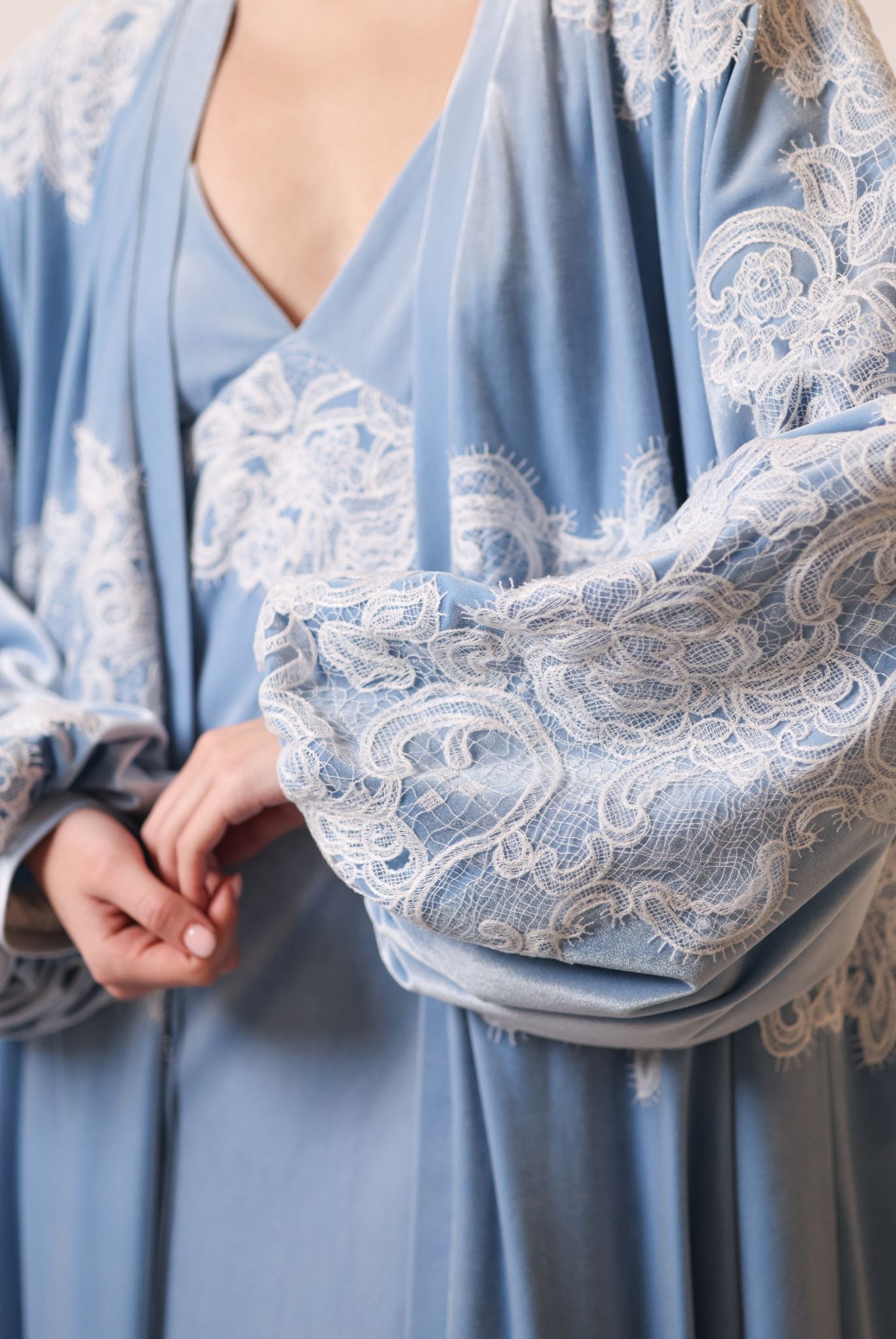 Close-up of the voluminous balloon sleeves adorned with delicate lace patterns, capturing the soft drama of velvet.
