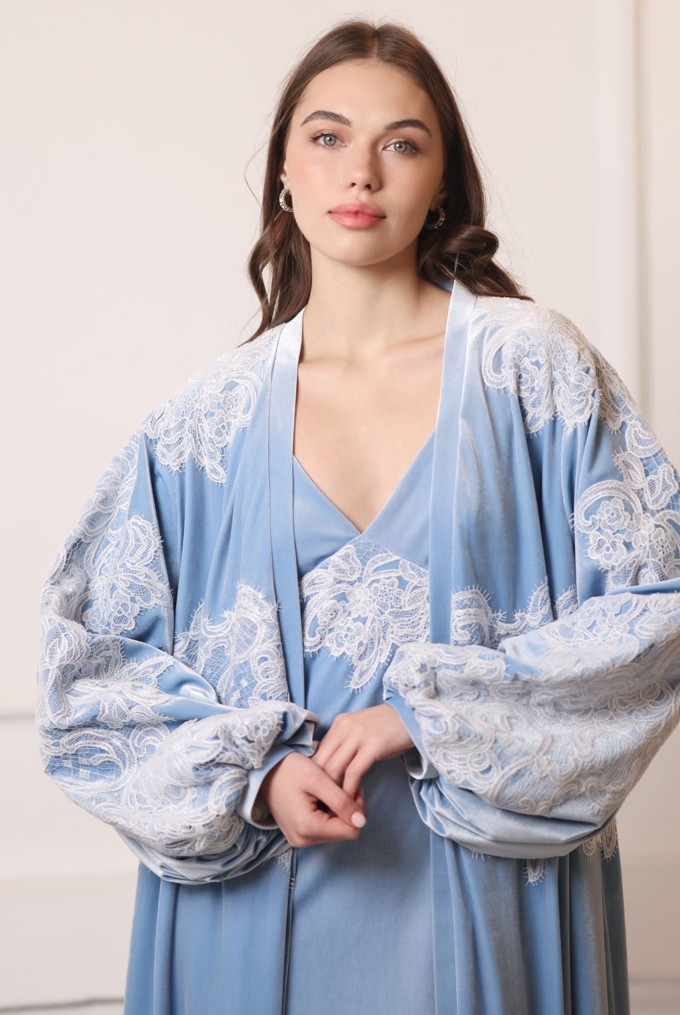 Shot from head to waist capturing the poetic movement of airy balloon sleeves with lace-trimmed wrists.