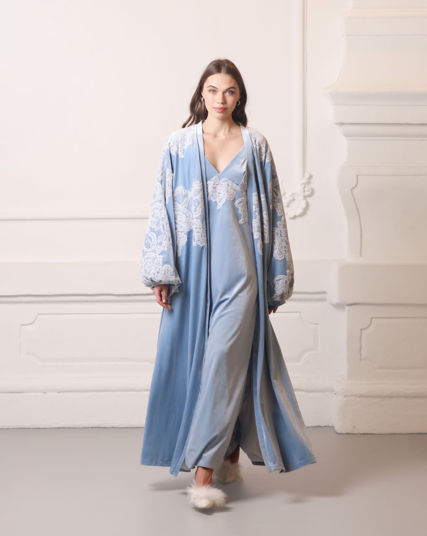 A flowing Velvet Robe and Nightgown Set in motion, showcasing the regal blue fabric and graceful silhouette.