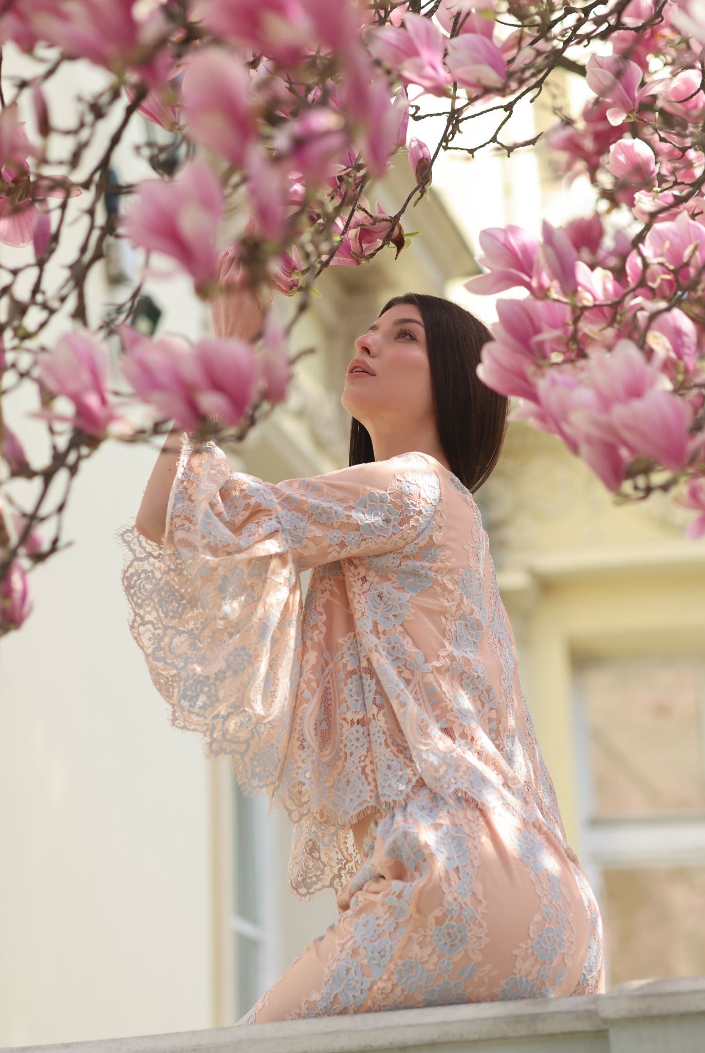 A poetic close-up of a girl smelling a magnolia flower, capturing a delicate moment of softness and character.