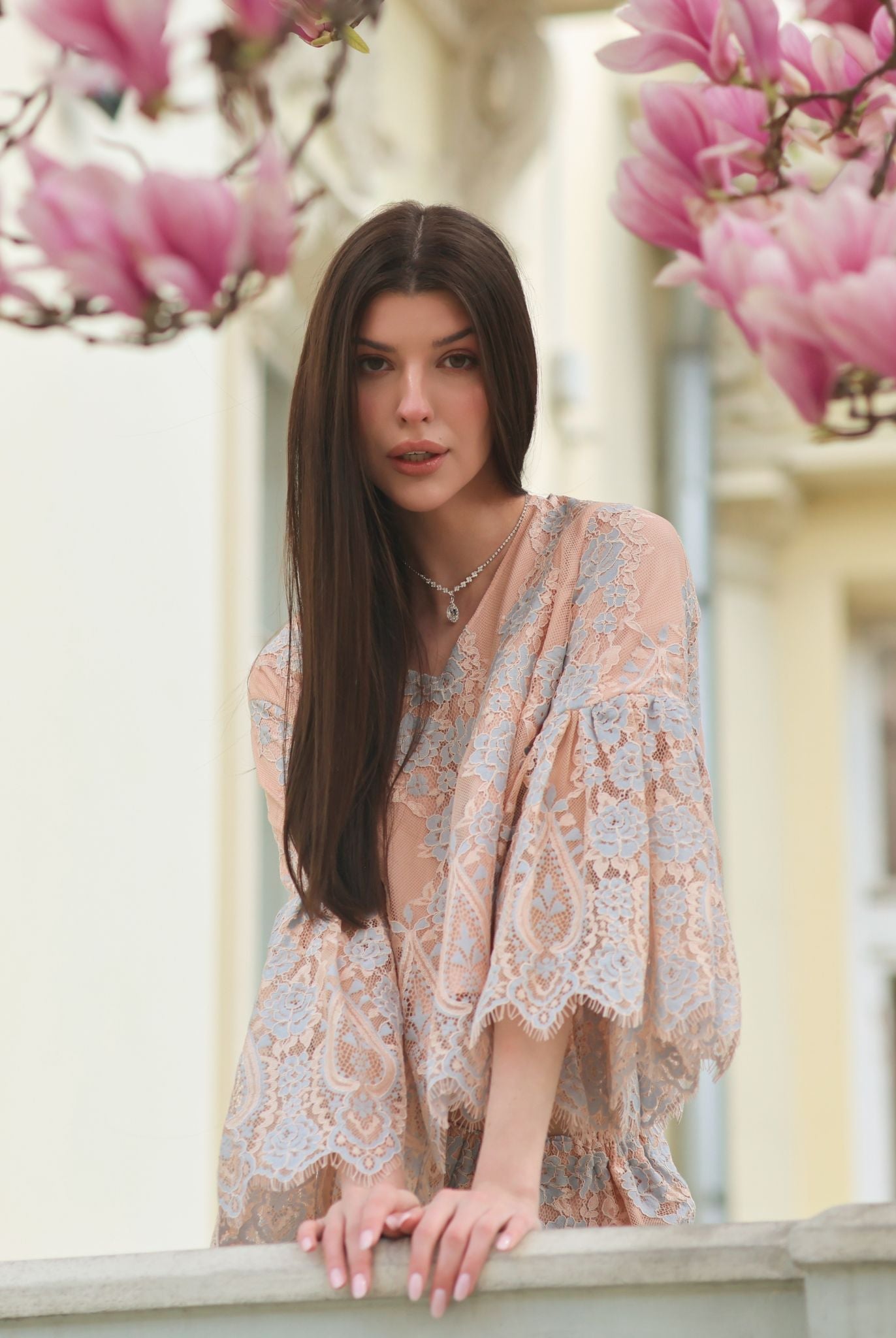 A serene shot on a balcony near magnolia trees, emphasizing a peaceful and elevated morning ritual in cozy attire.