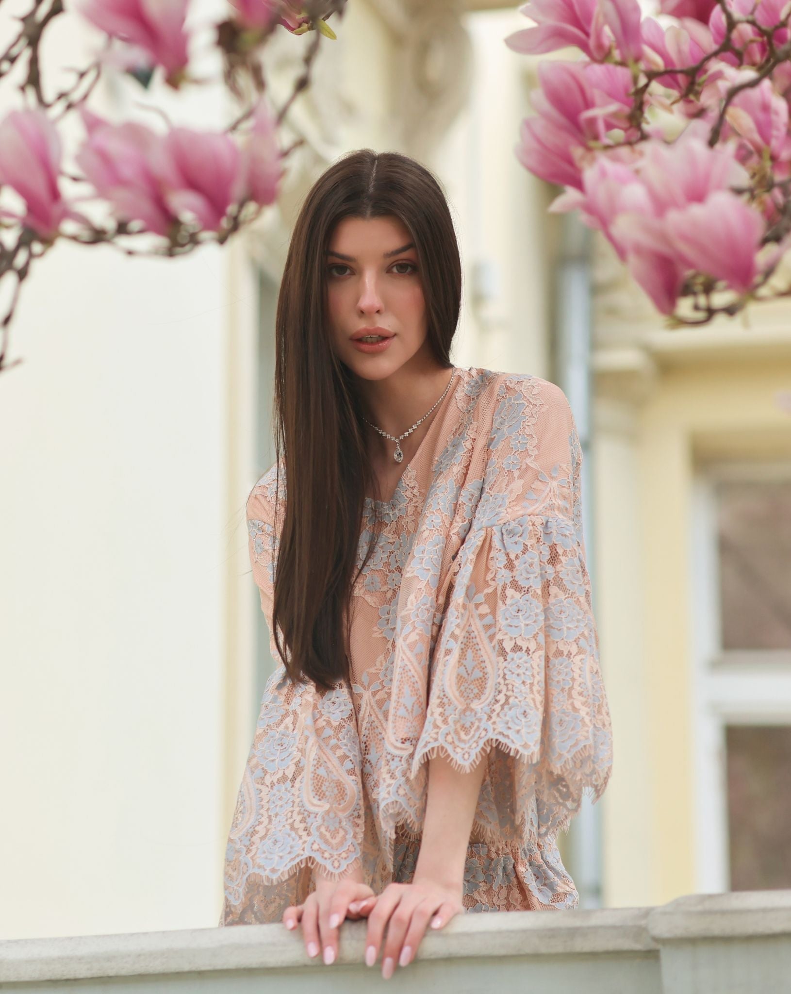 A serene shot on a balcony near magnolia trees, emphasizing a peaceful and elevated morning ritual in cozy attire.