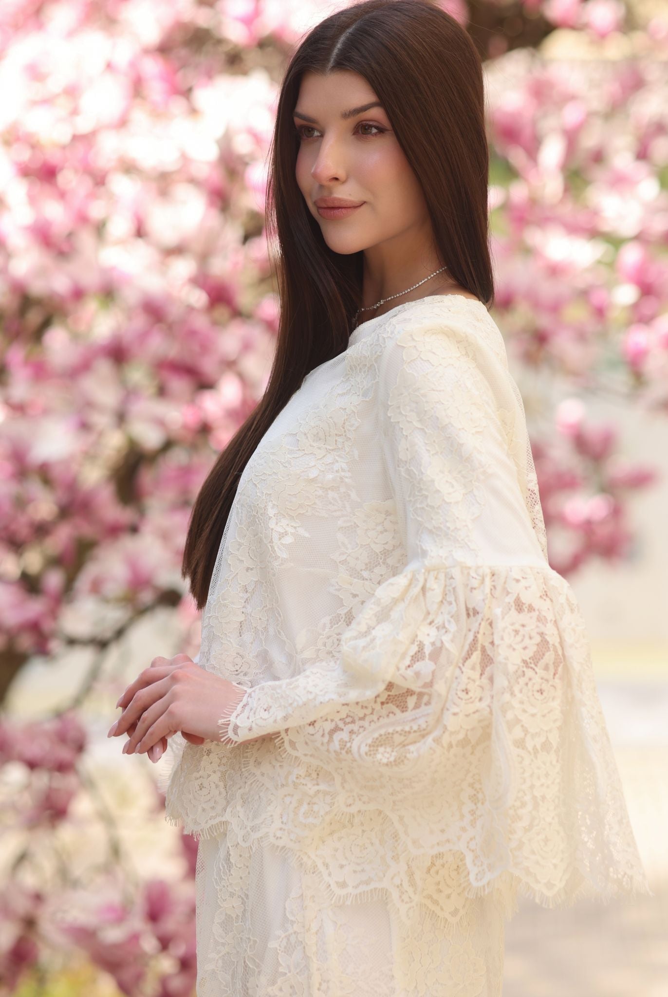 A side view from head to hips, highlighting the wide statement sleeves layered with intricate lace for a refined touch.