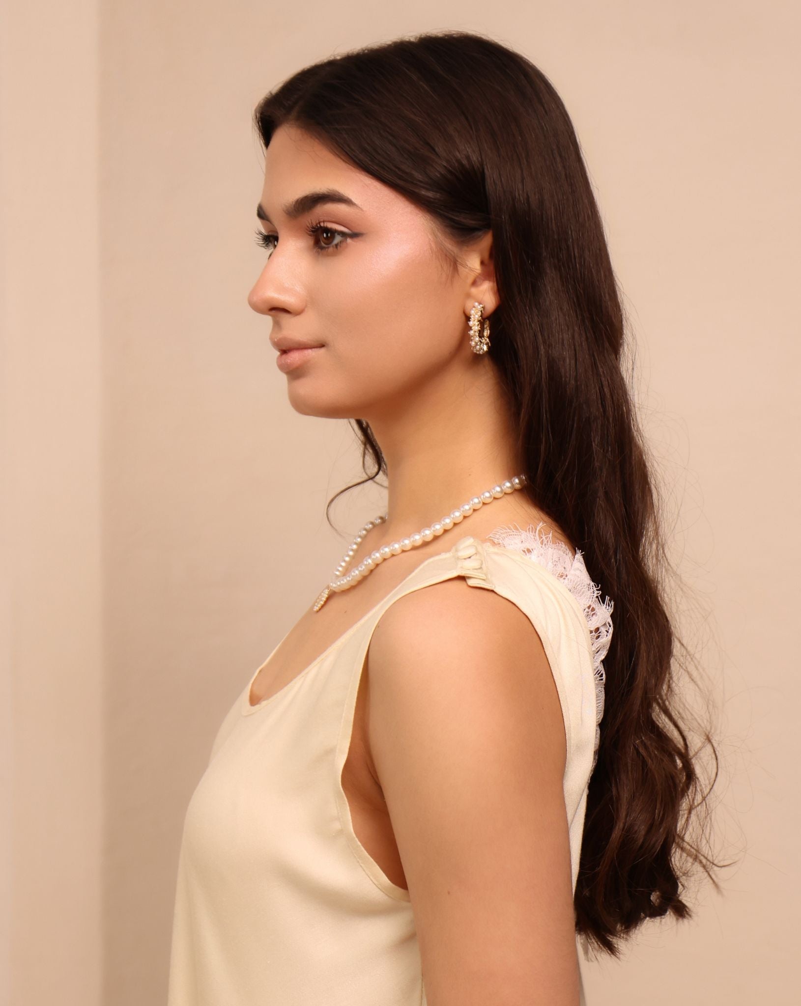 A close-up portrait focusing on the refined lace details and the practical shoulder buttons of the maternity set.