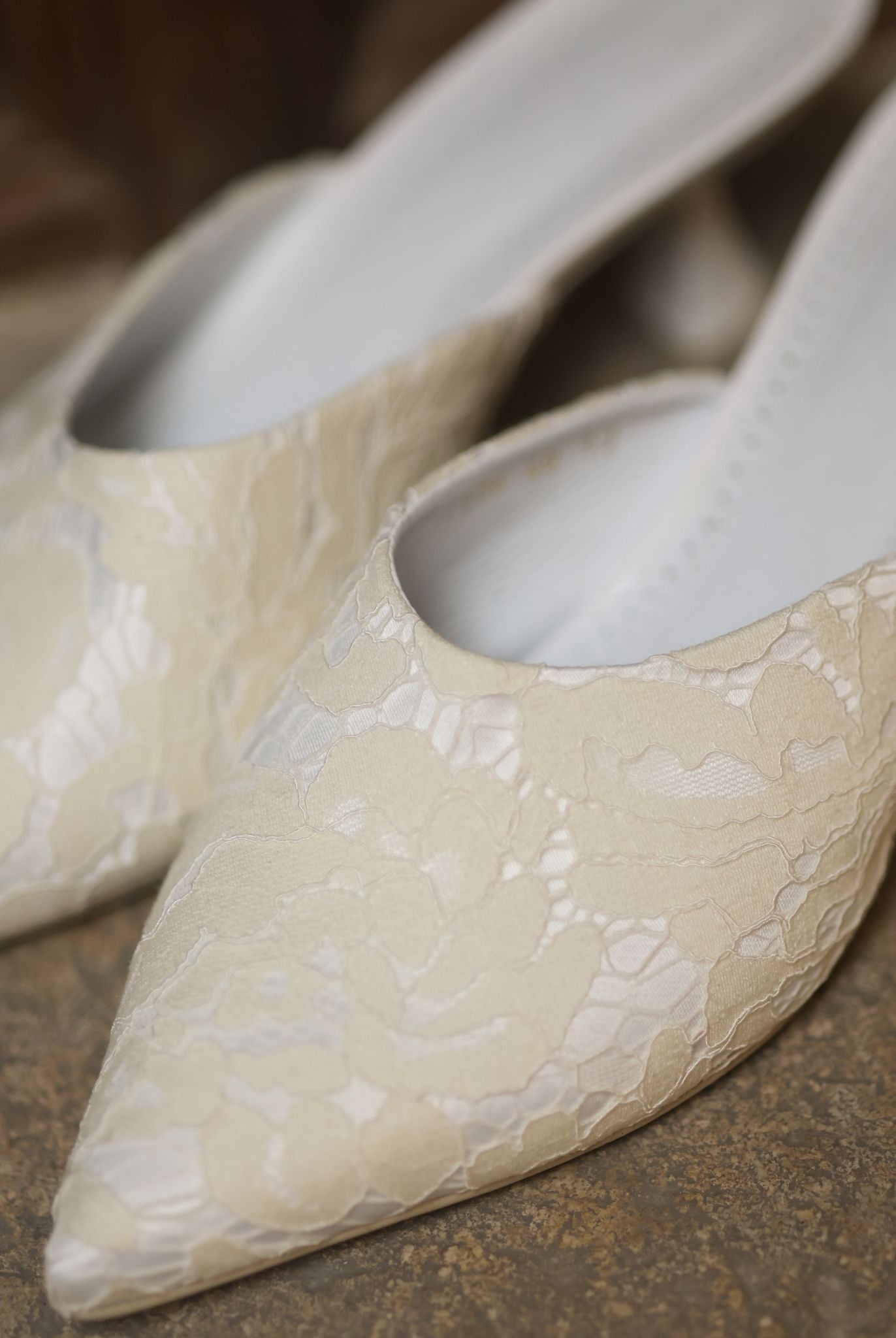 A close-up of the Satin Slippers, showcasing the pointed-toe silhouette and luminous satin finish.