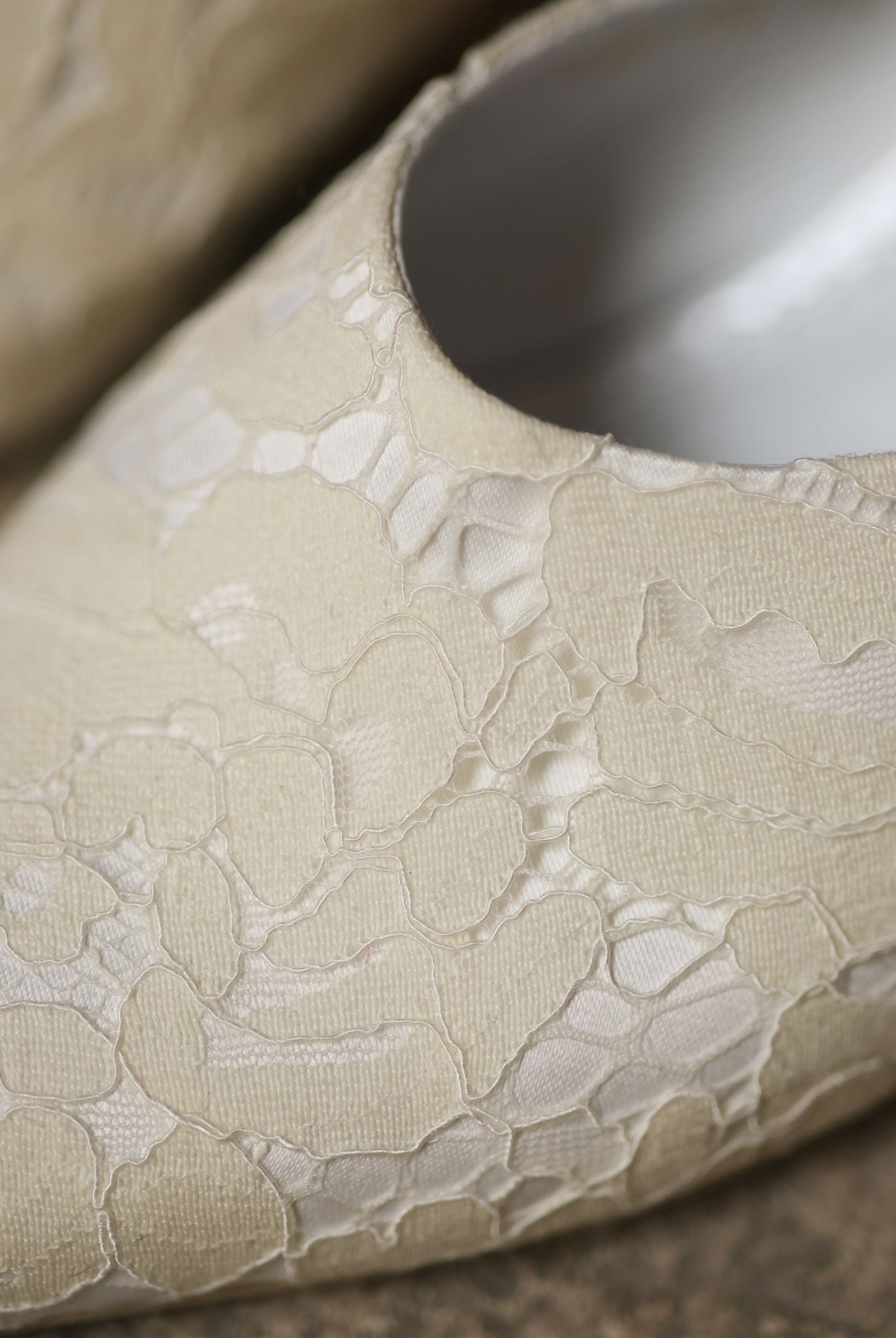 Macro shot of the slipper, focusing on the intricate lace adornment and the high-quality satin texture.
