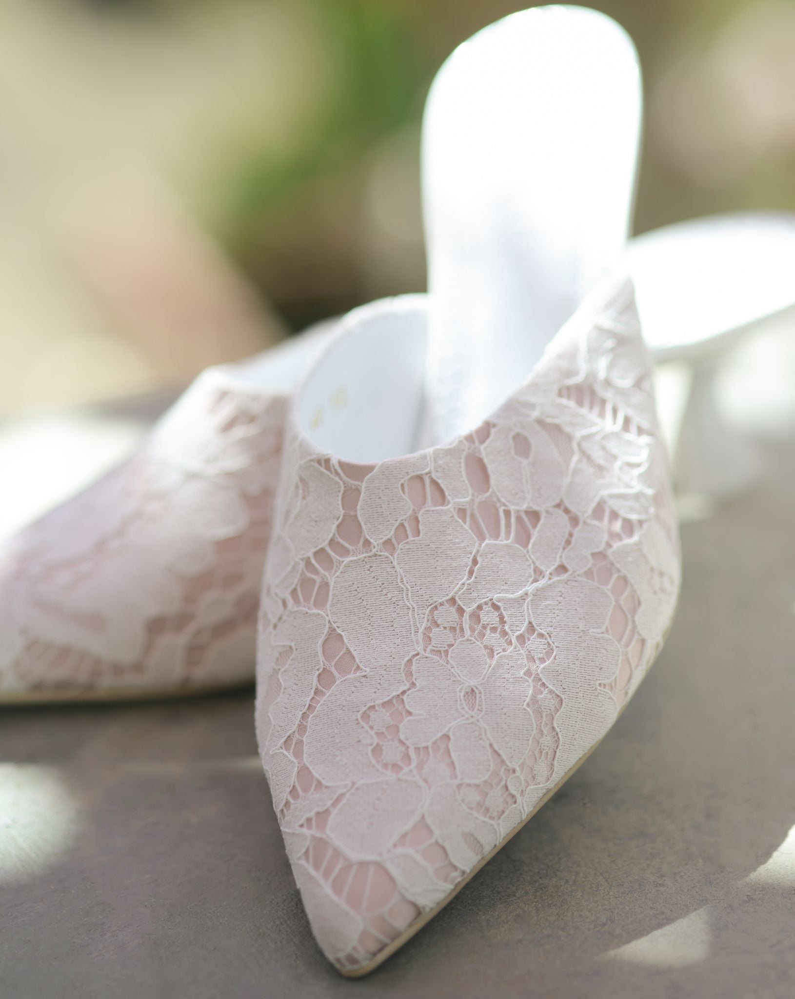 A static shot of the Satin Slippers on a balcony, highlighting the 5 cm heel and the luminous satin base.